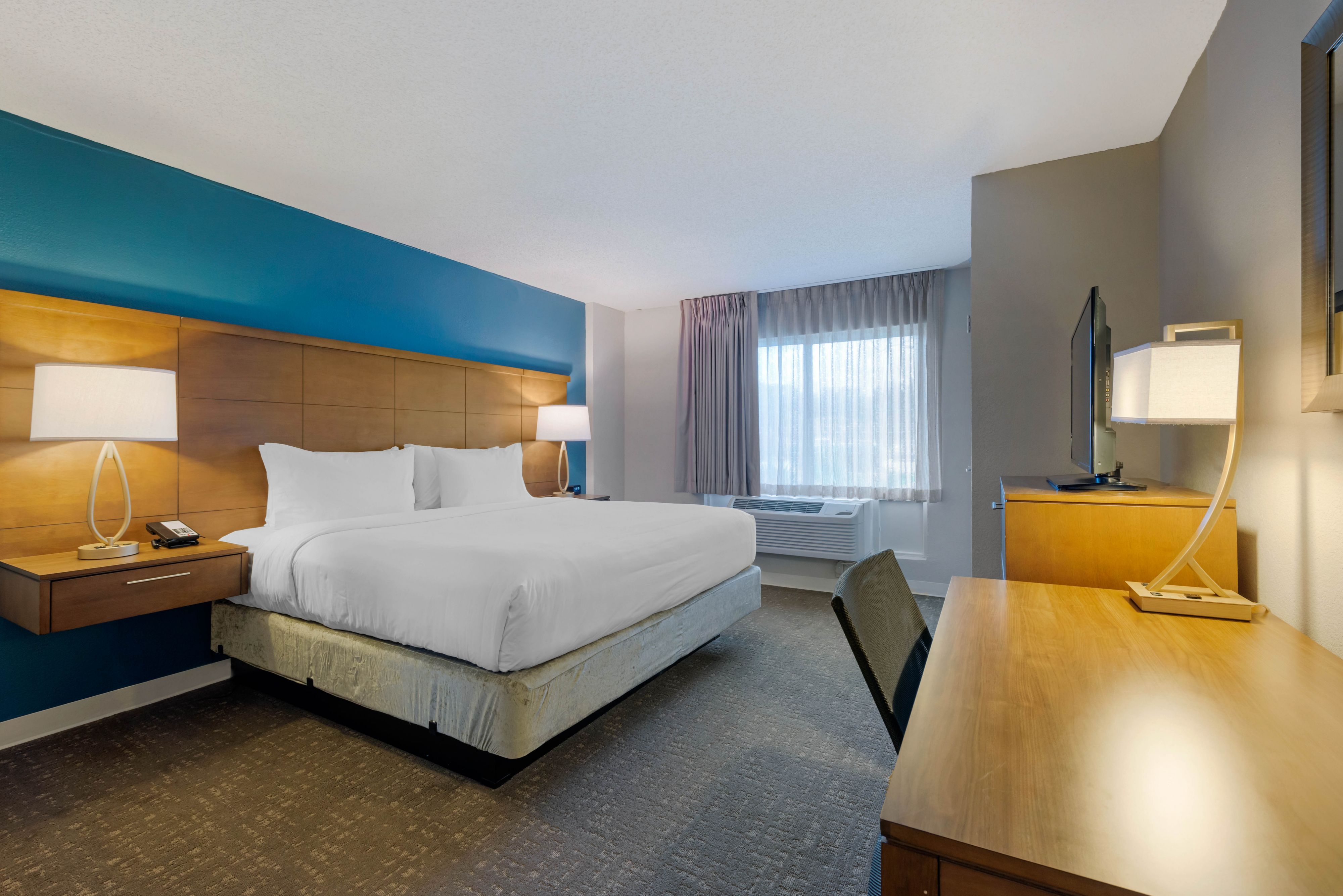 image King-size bedroom with large bed, desk, and lamps.