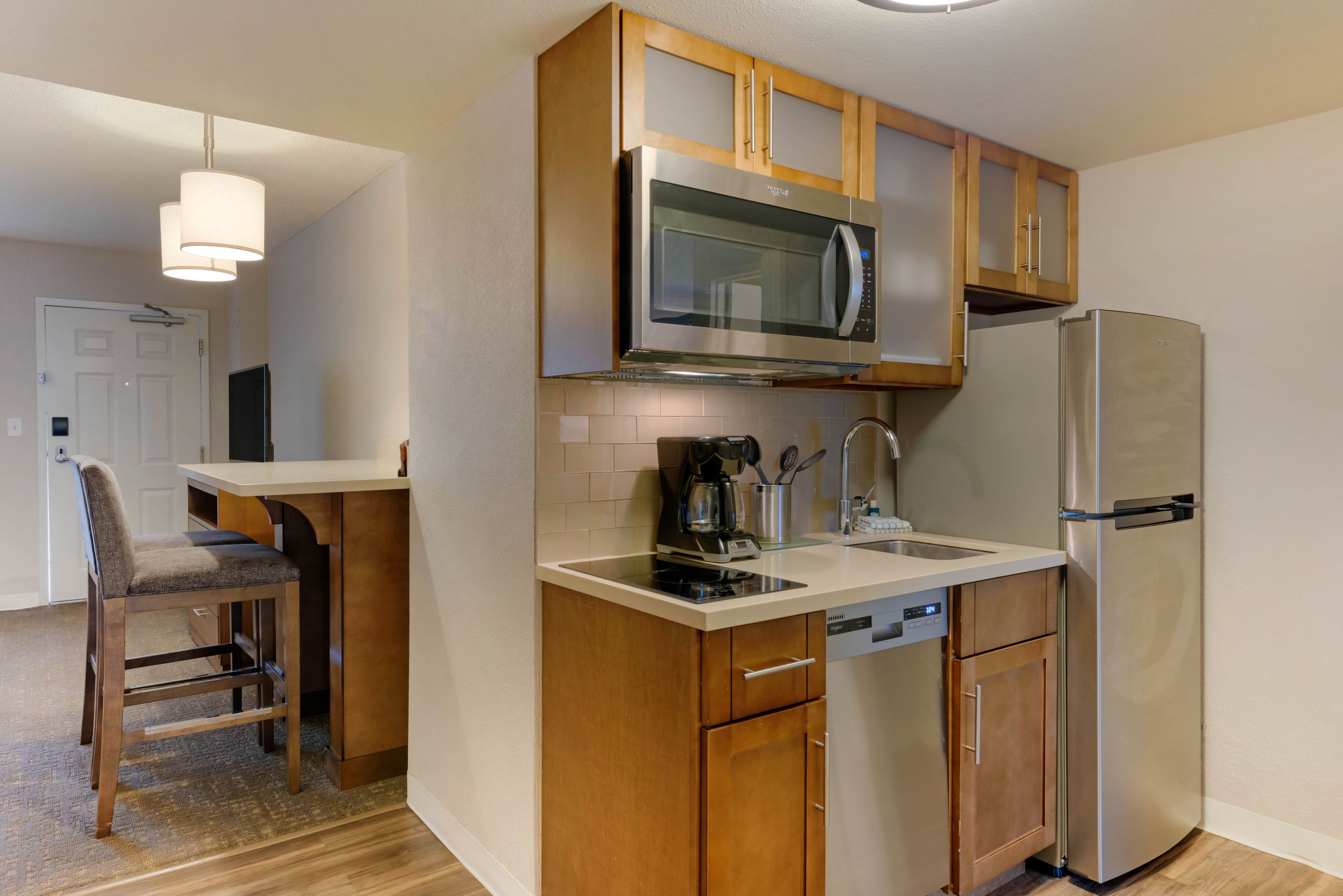 image Modern kitchen layout with a microwave, dishwasher, and sink.