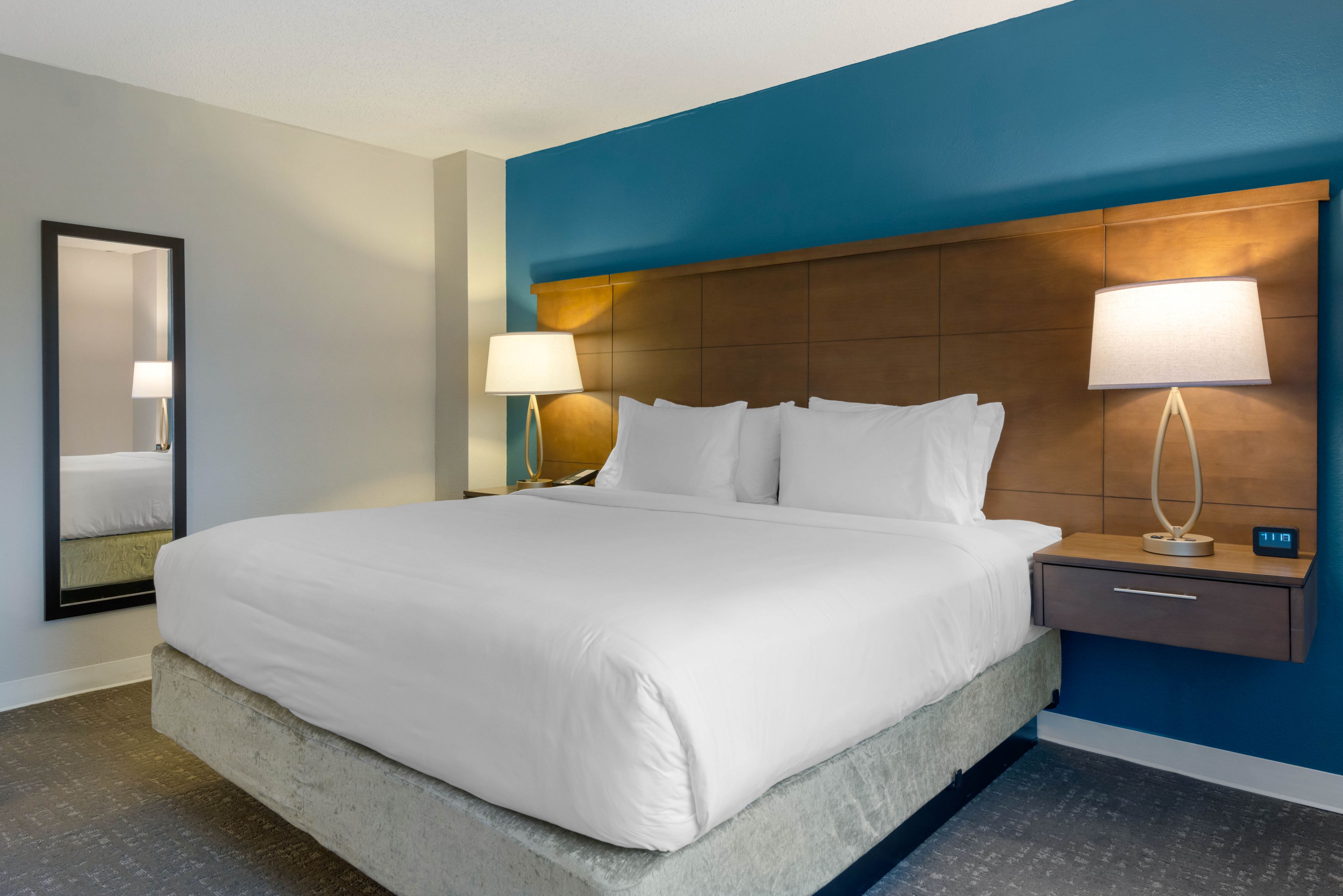 image King-size bed paired with a stylish lamp and mirror.