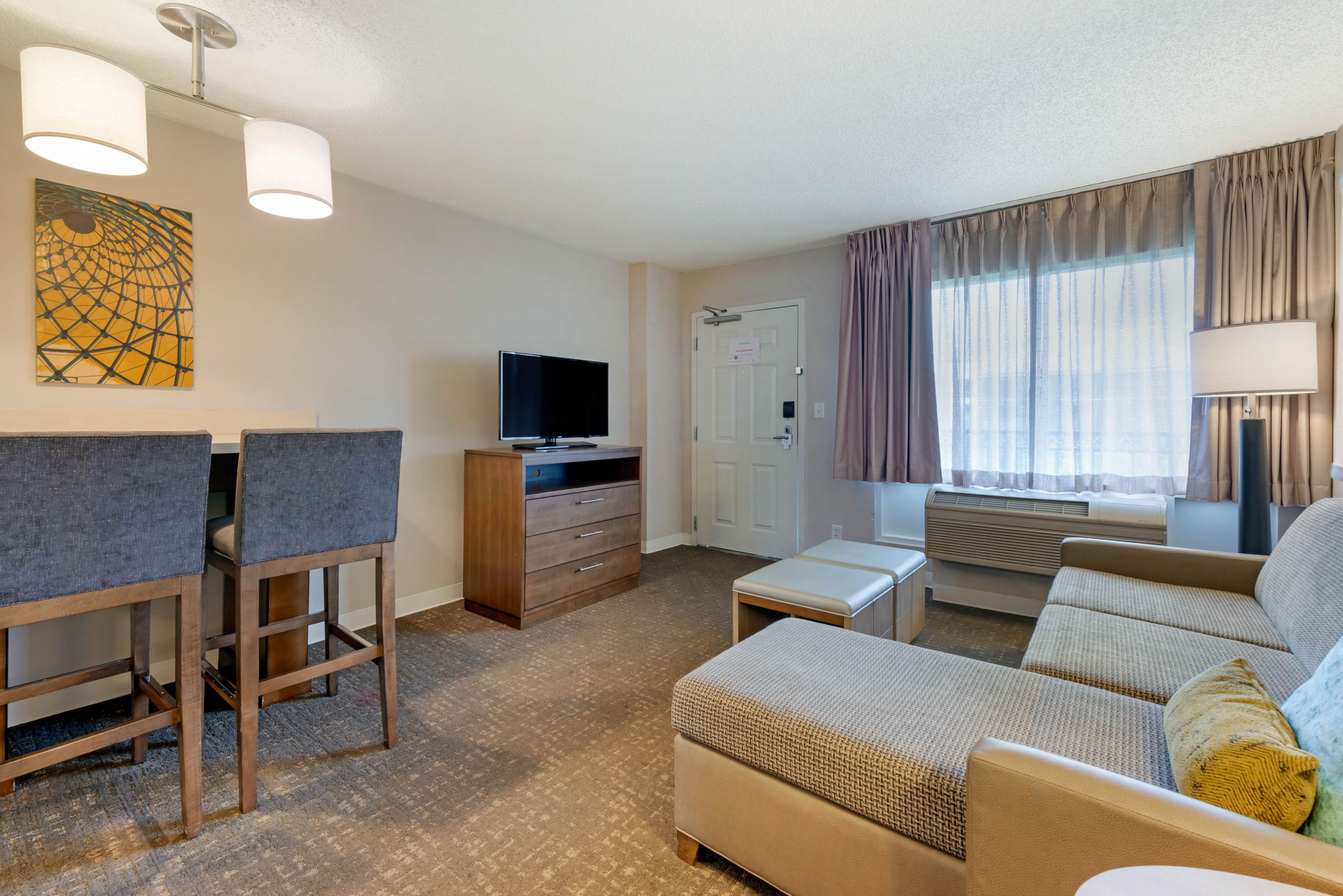 image Living area with a couch, TV, and dining space.