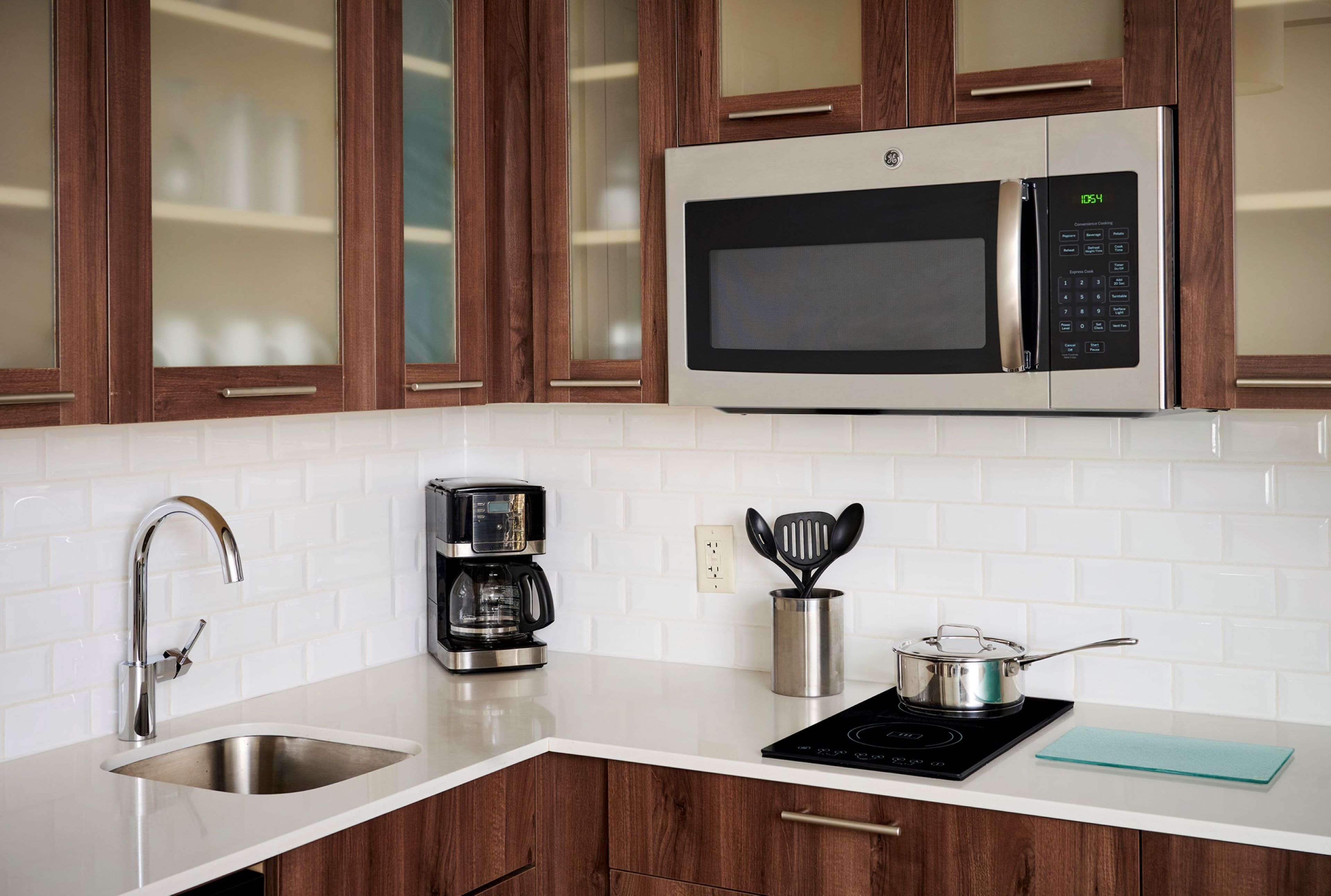 image Kitchen with wood cabinets, microwave, and coffee maker.