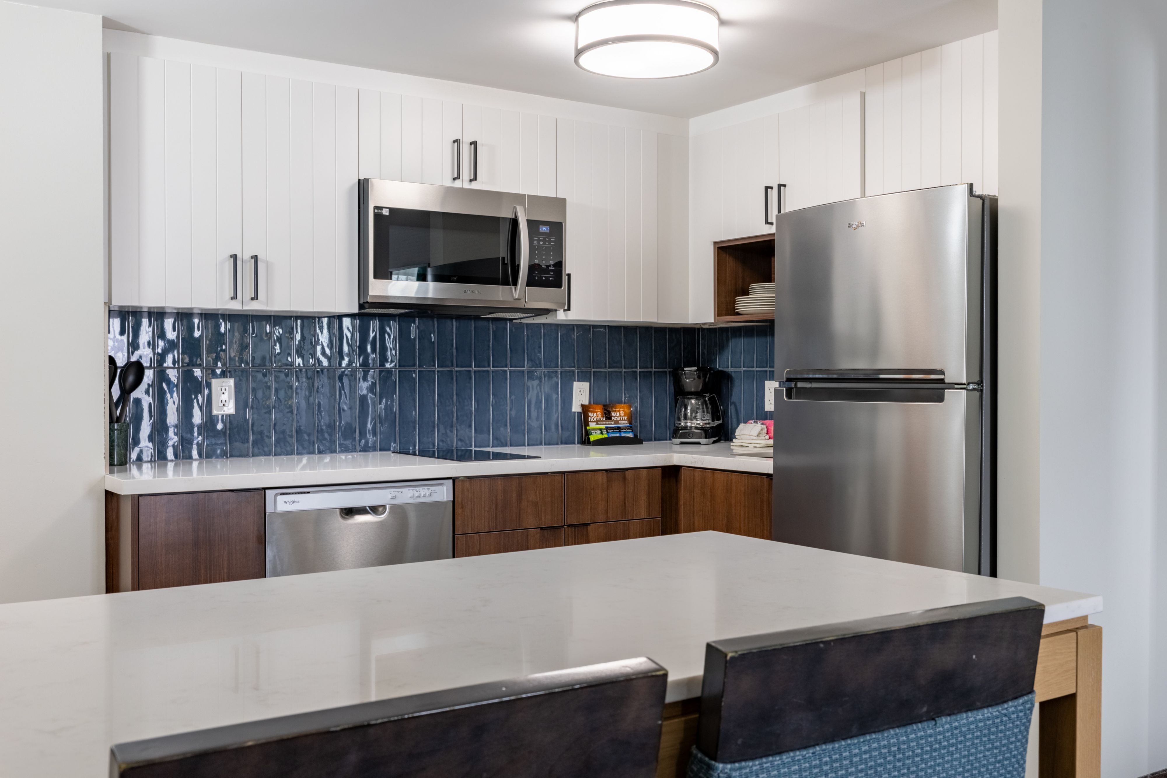 image Full kitchen with stainless steel appliances and a blue-tiled backsplash makes cooking meals simple during your stay.