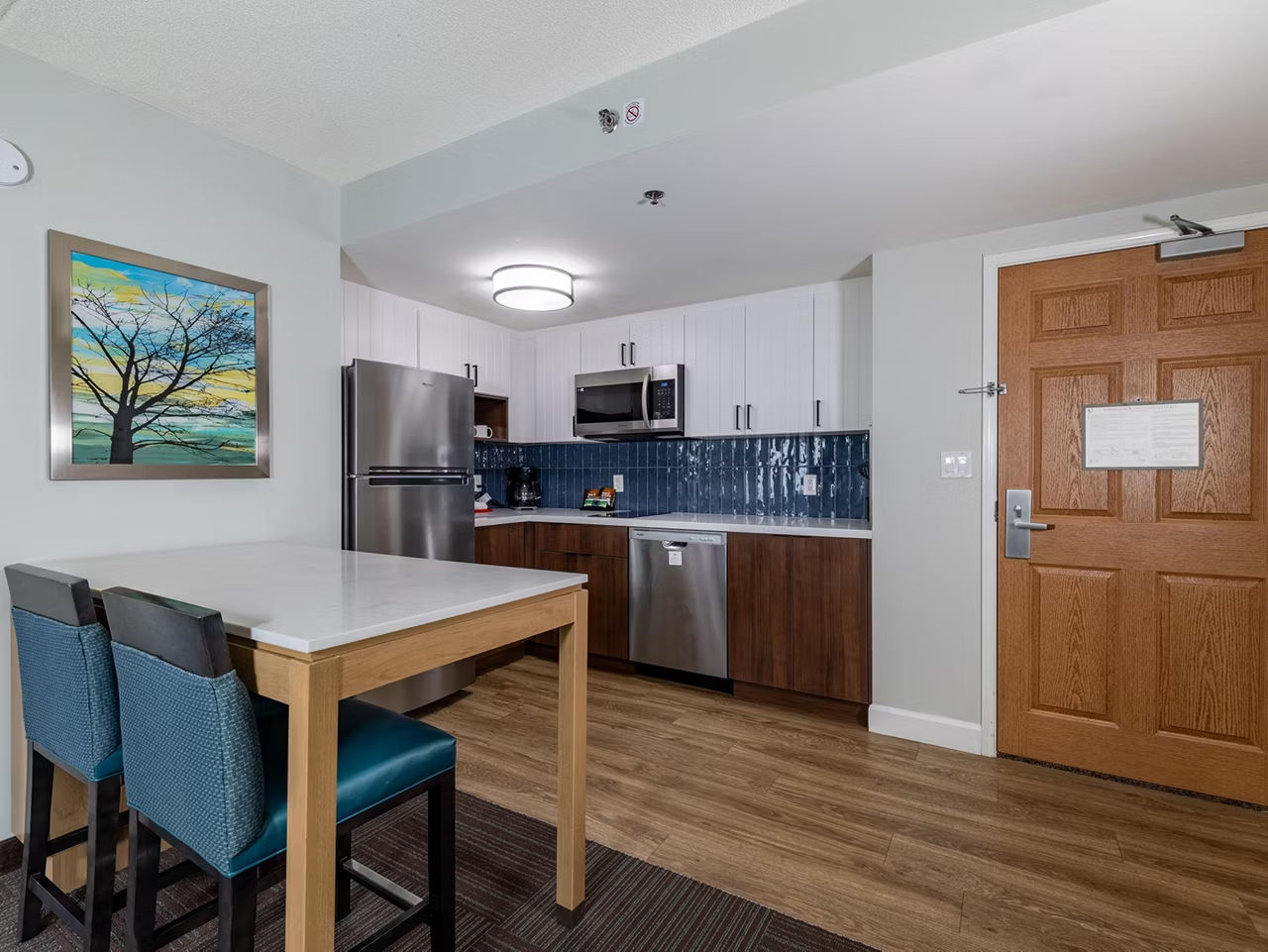 image Dining table in the kitchen area comes with full-size appliances and a vibrant backsplash for meal prep.