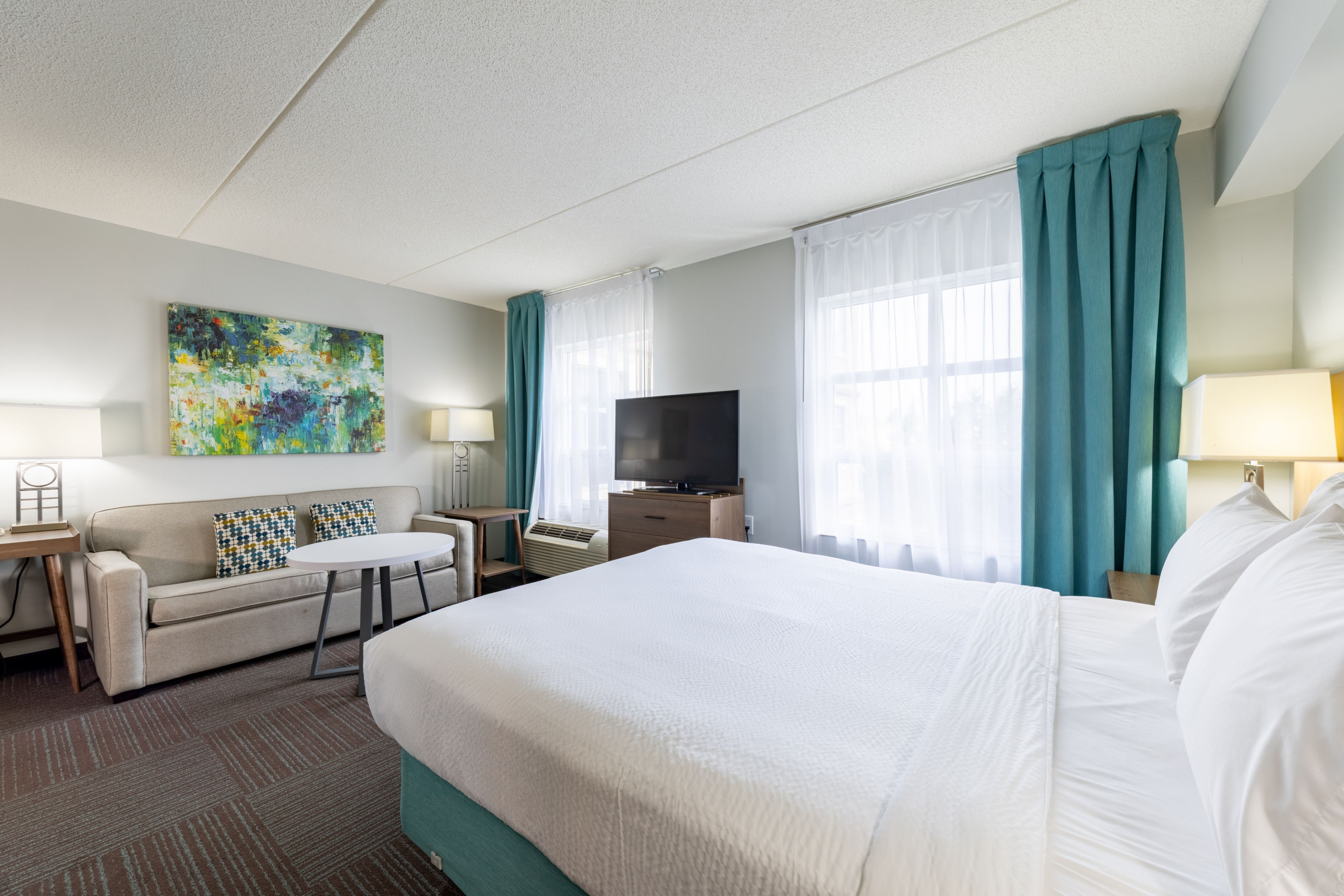 image Comfortable queen bedroom with modern decor and flat-screen TV.