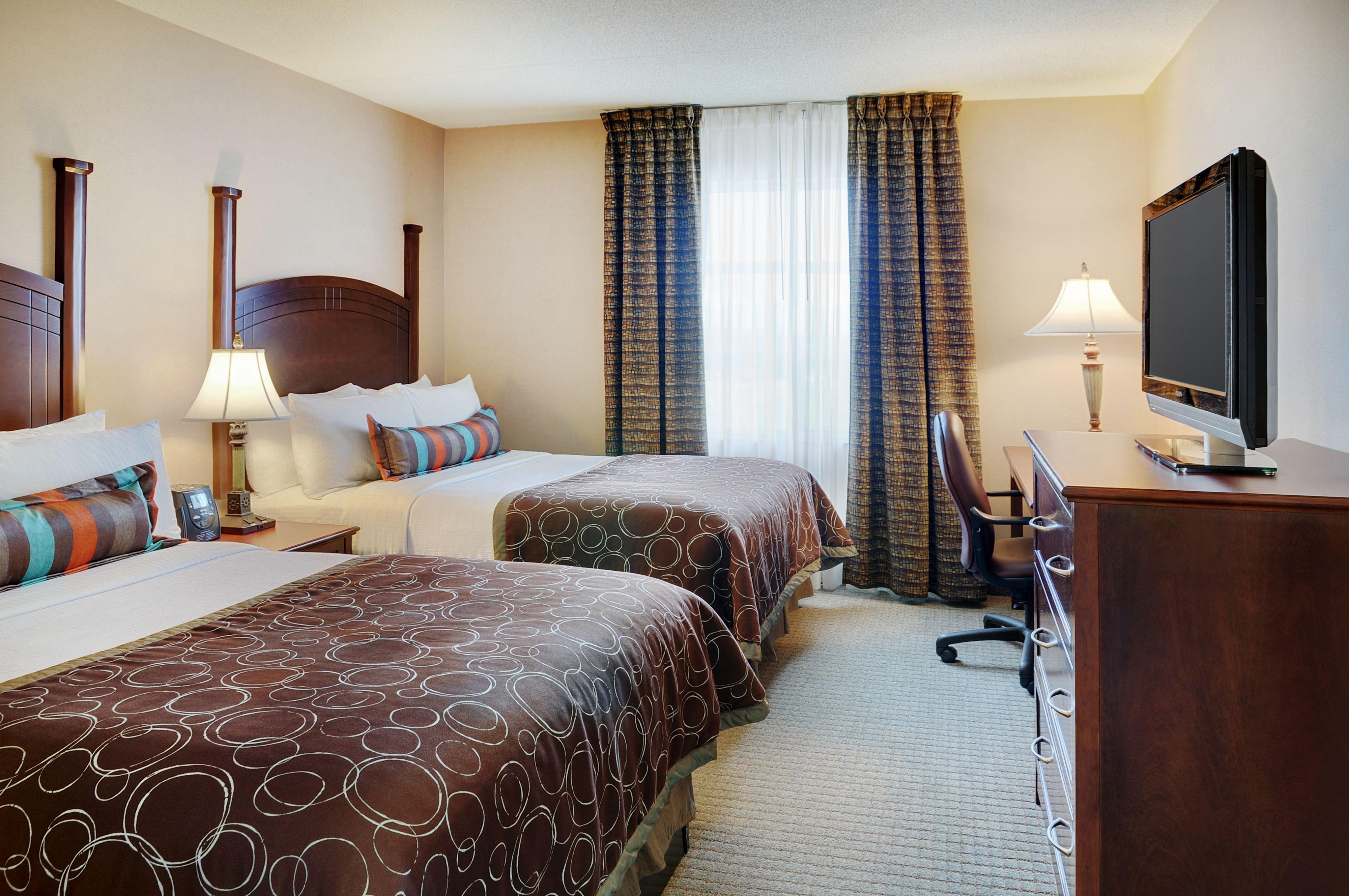 image Two double beds in a bright, well-appointed bedroom.