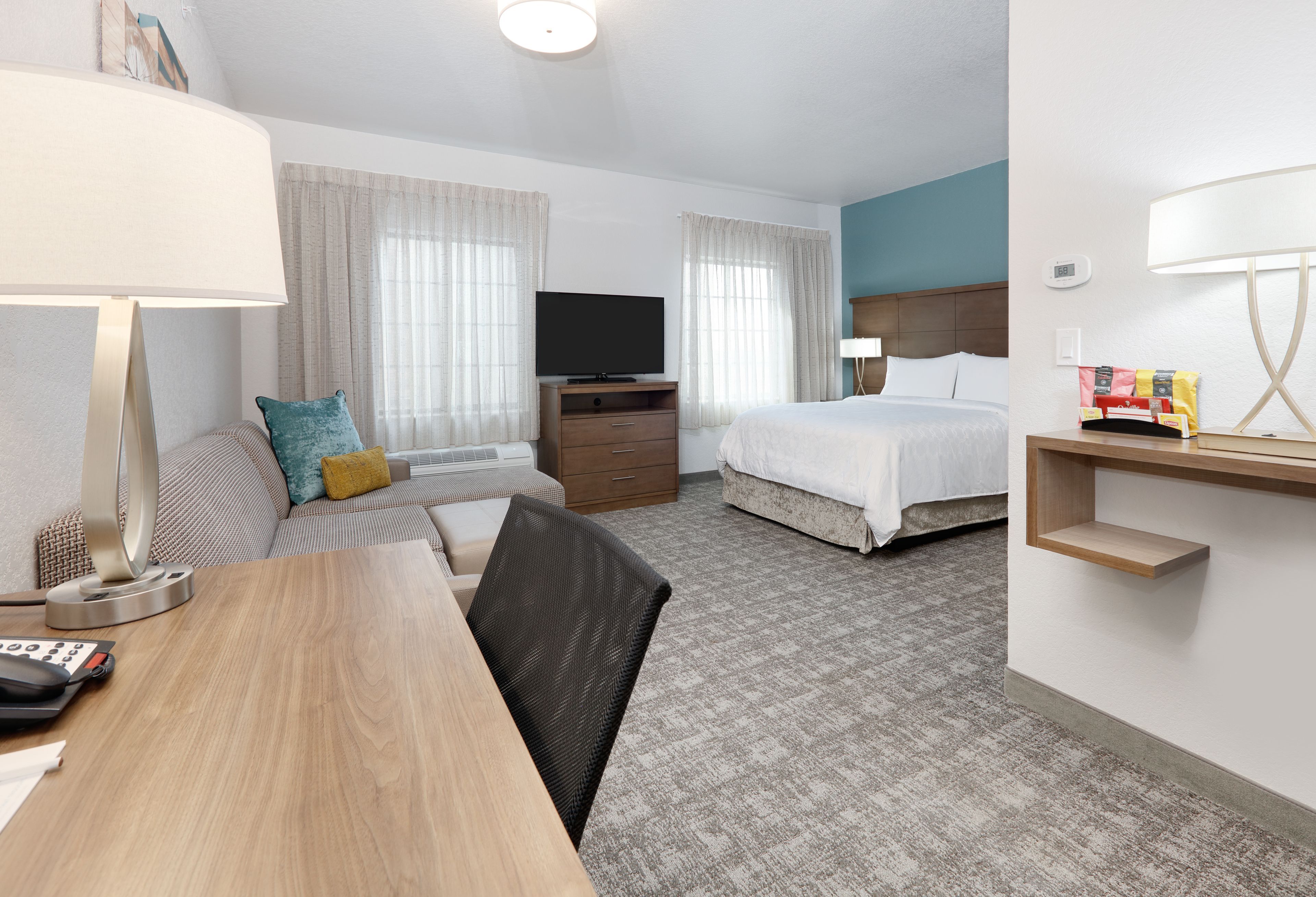 image Bright studio suite with queen bed, dining area, and sofa seating.