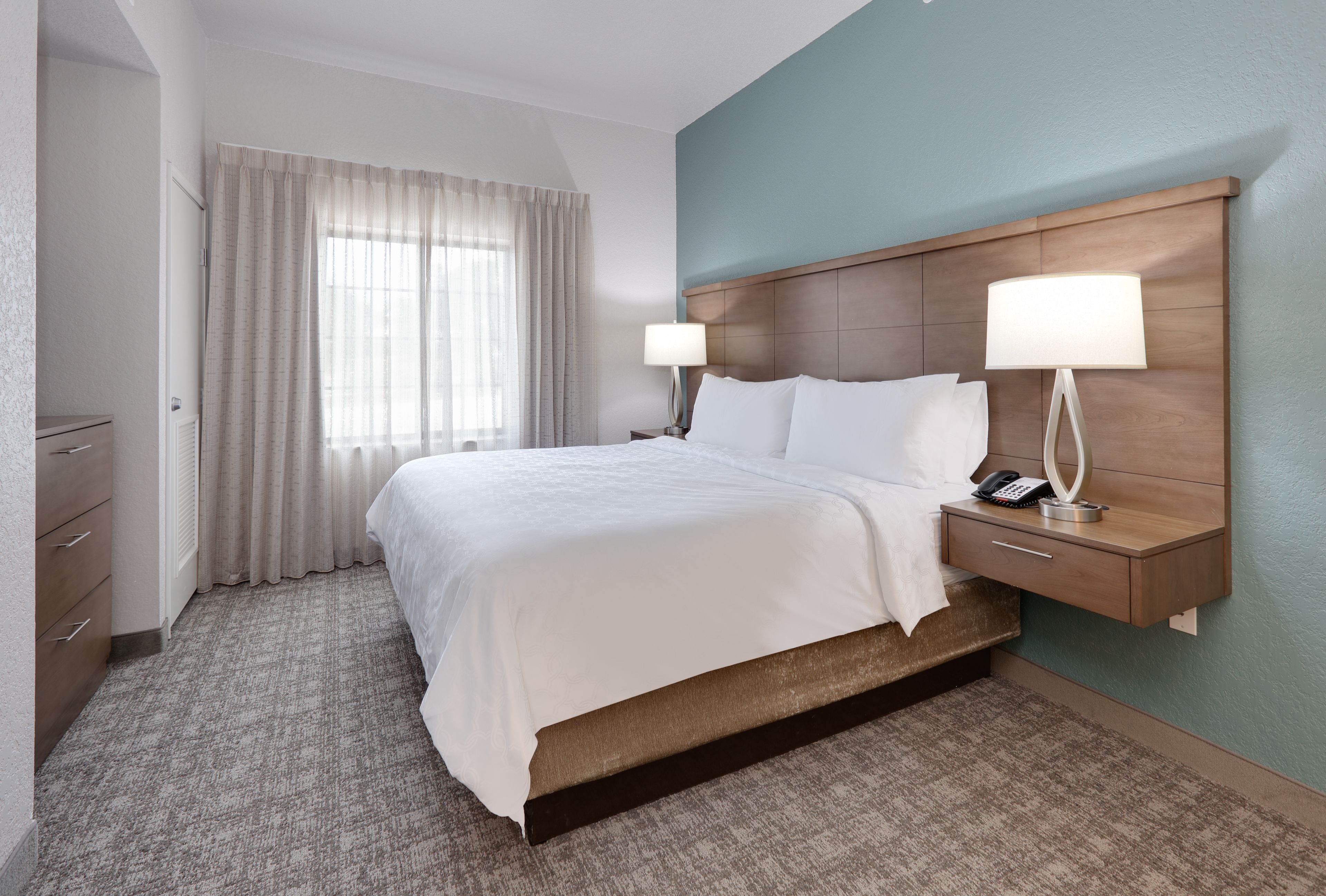 image Comfortable king bedroom with large windows and plush bedding.