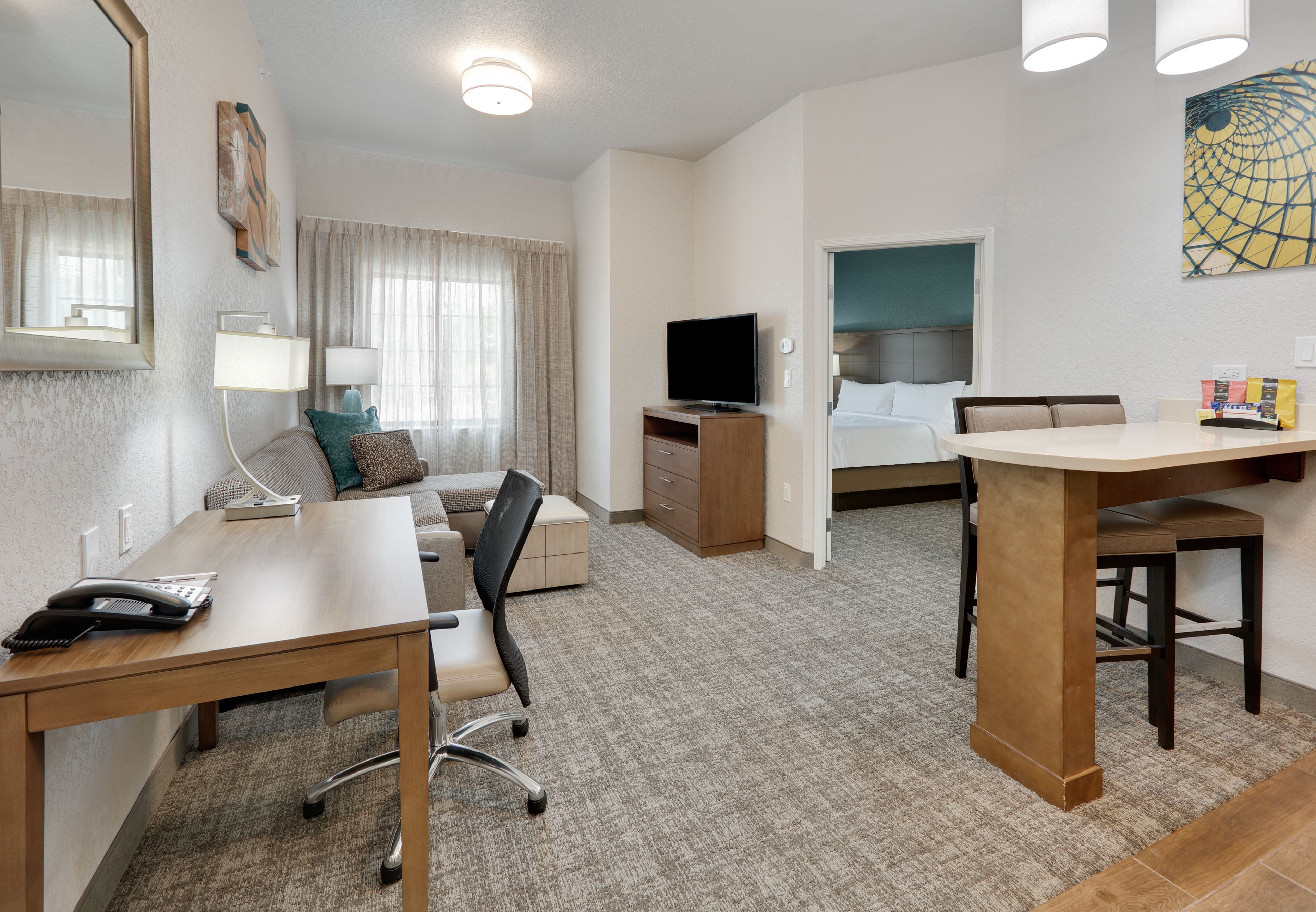 image Cozy living area with work desk and comfortable seating.