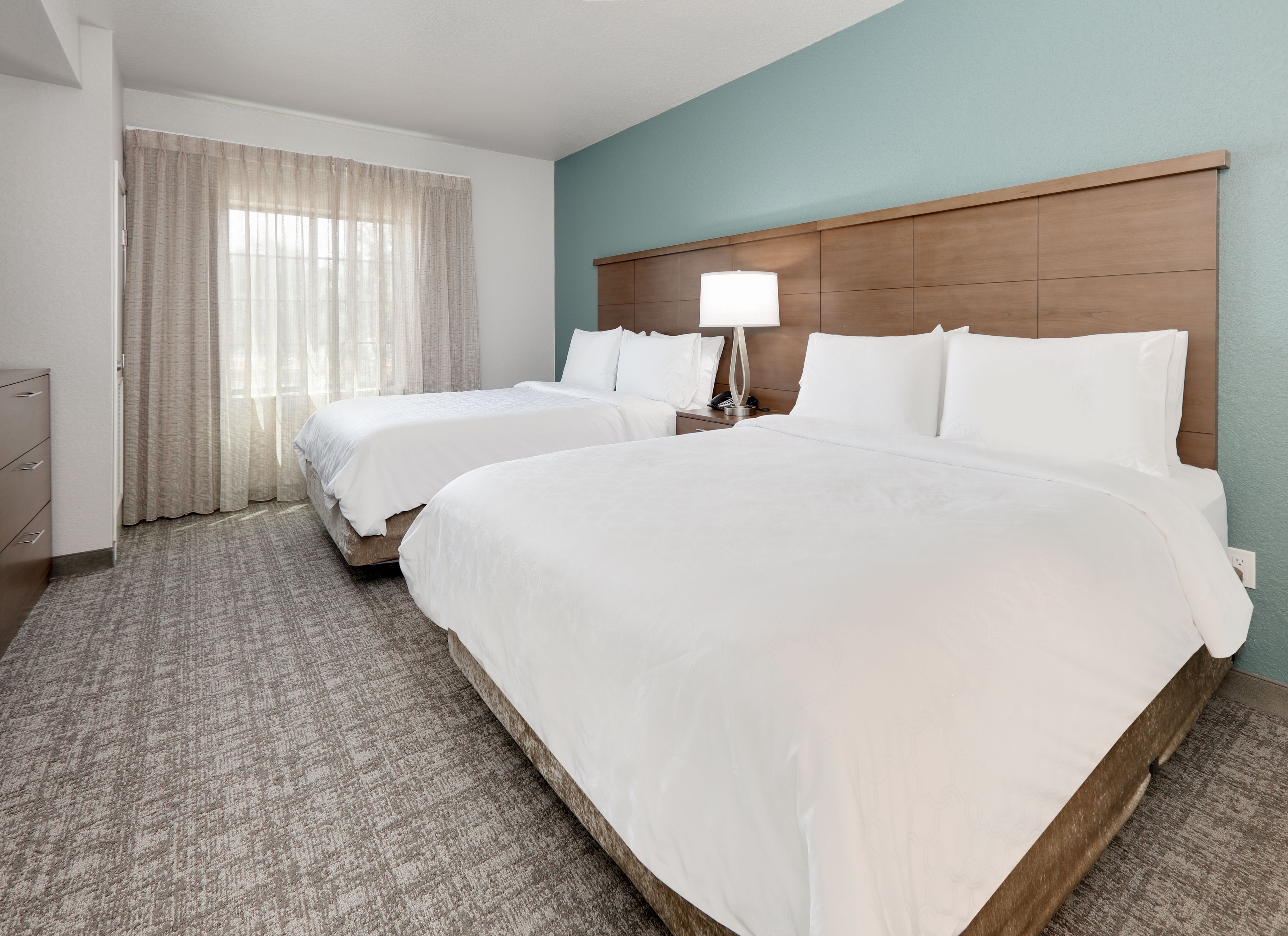 image Spacious bedroom with two comfortable beds and natural light.
