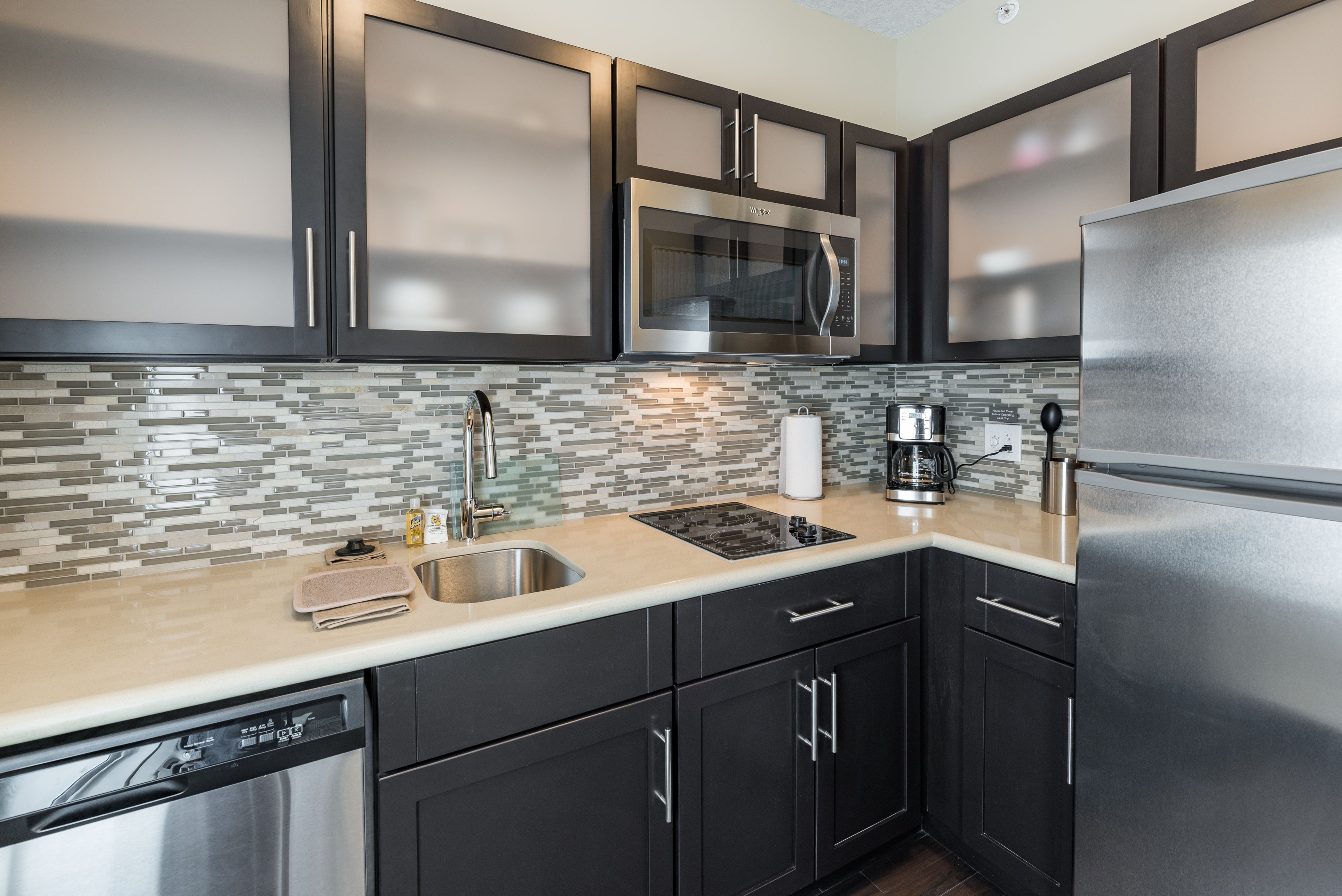 image Kitchenette with sleek cabinetry, full appliances, and coffee maker.