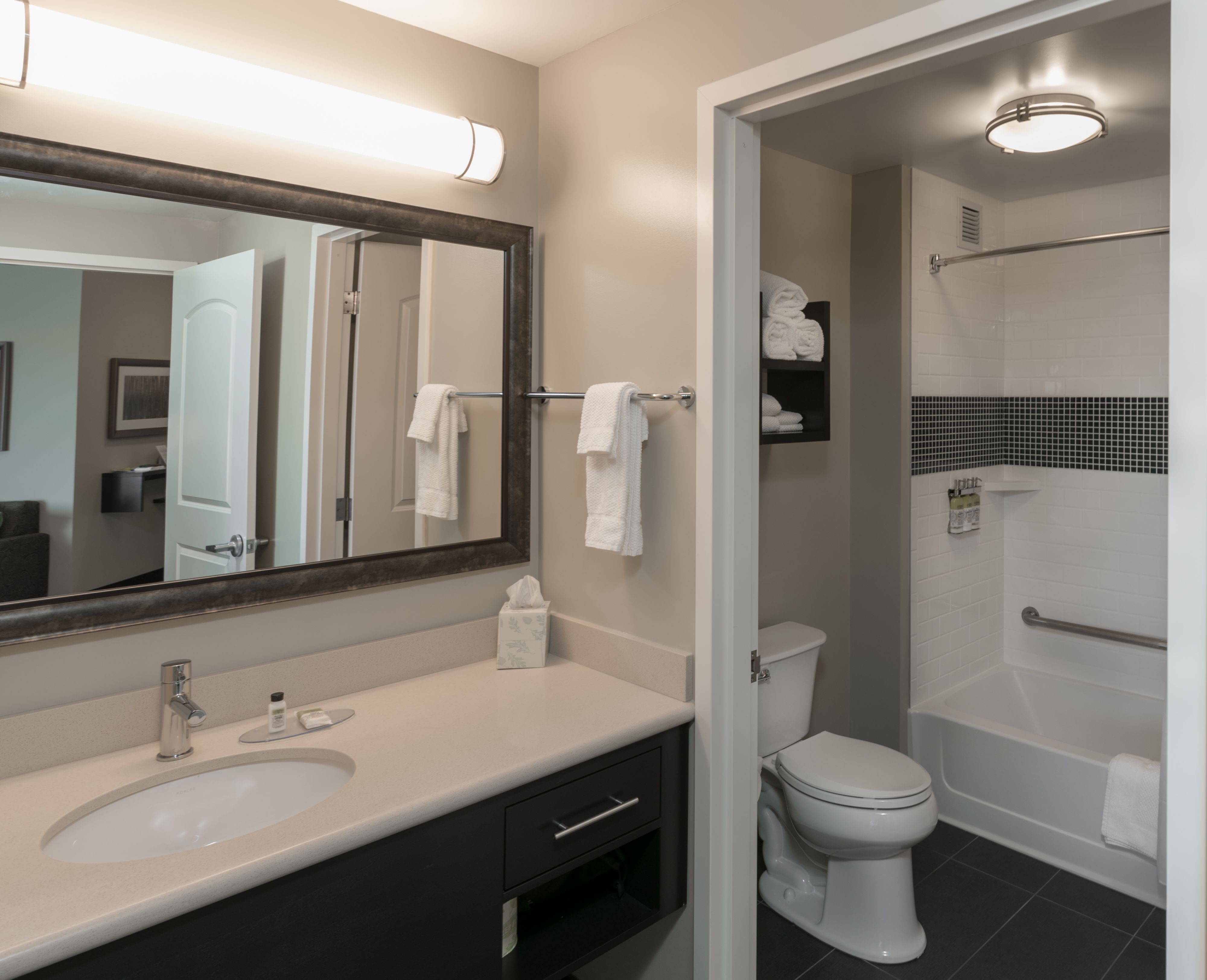image Bathroom with large mirror, fresh towels, and modern finishes.