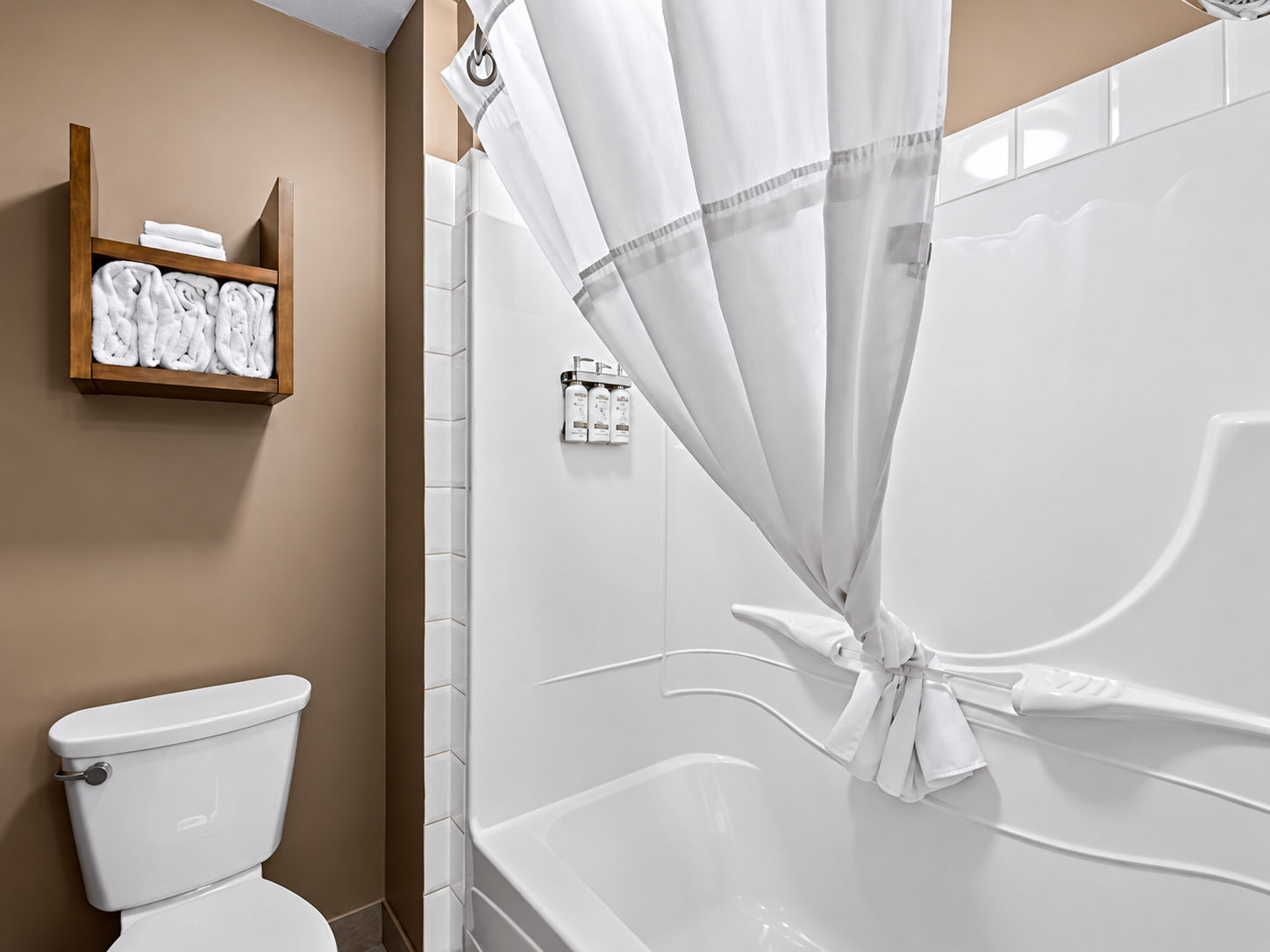 image Clean, bright bathroom with shower-tub combo and fresh towels within reach.