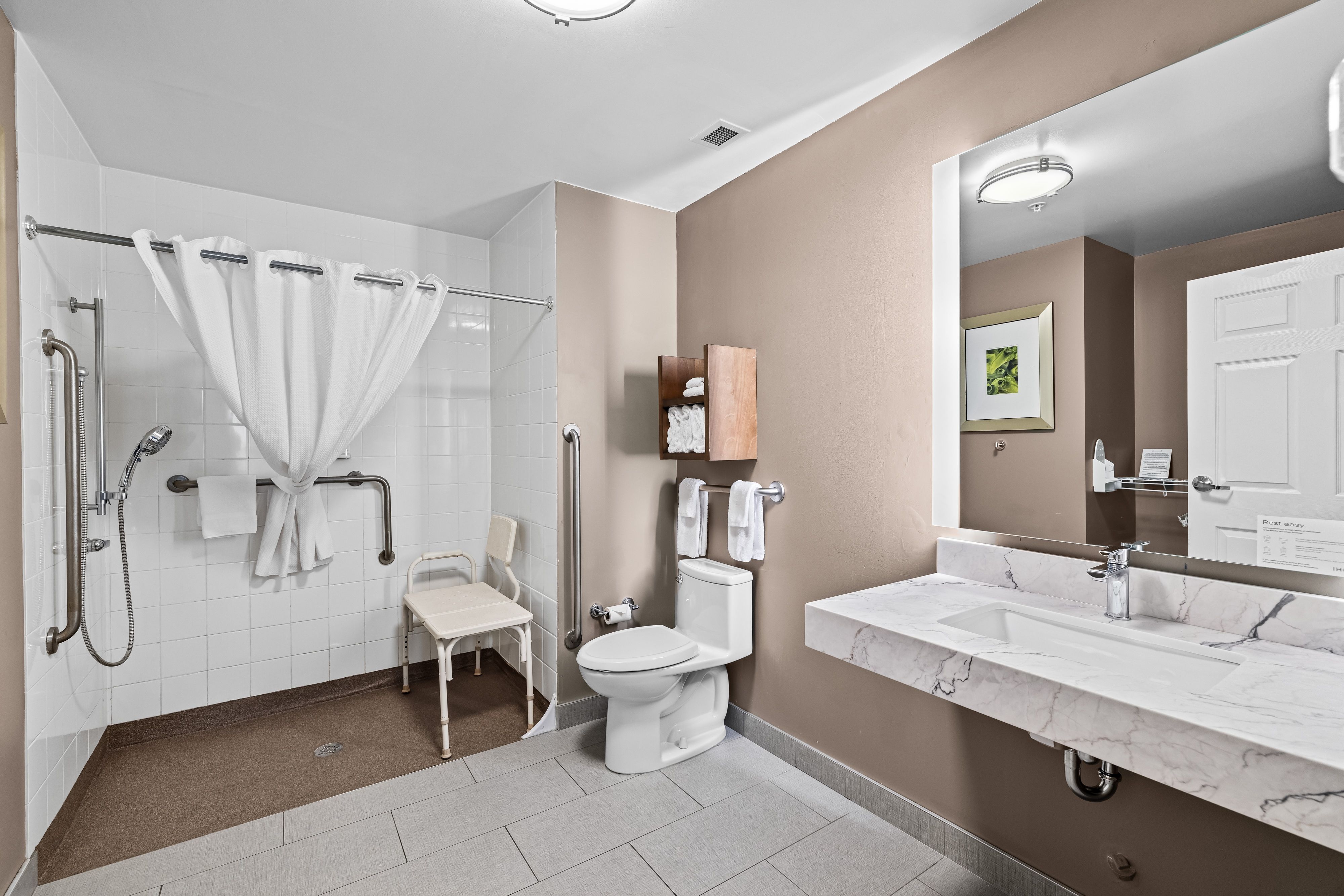 image Accessible bathroom with shower, toilet, and sink.