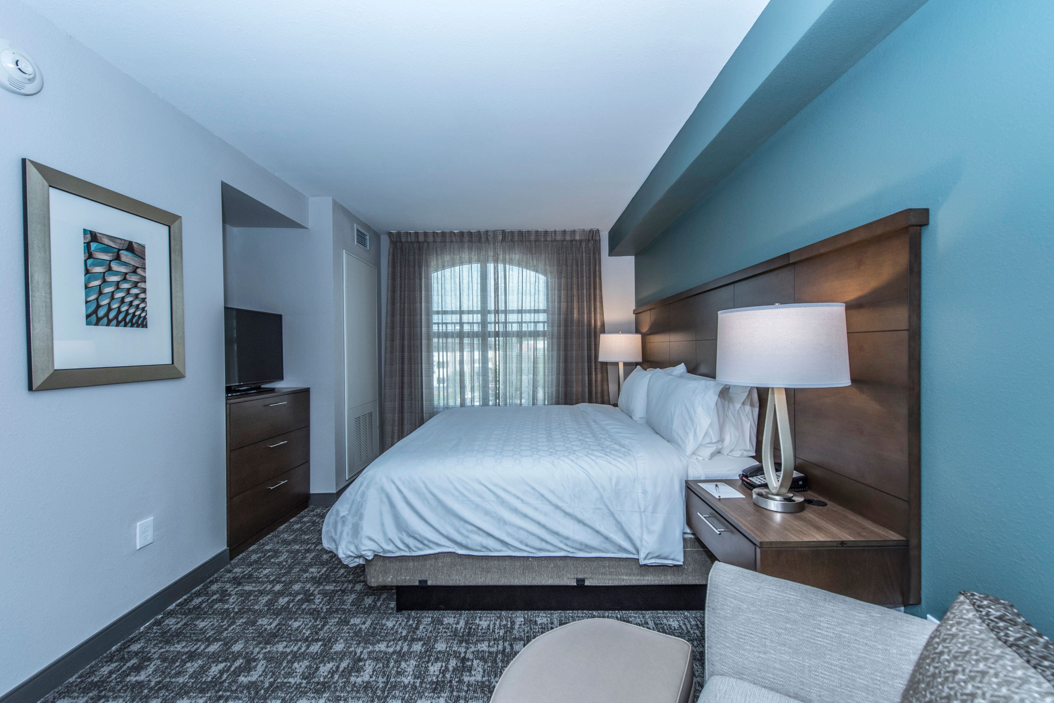 image King bedroom with nightstands, TV, and natural light.