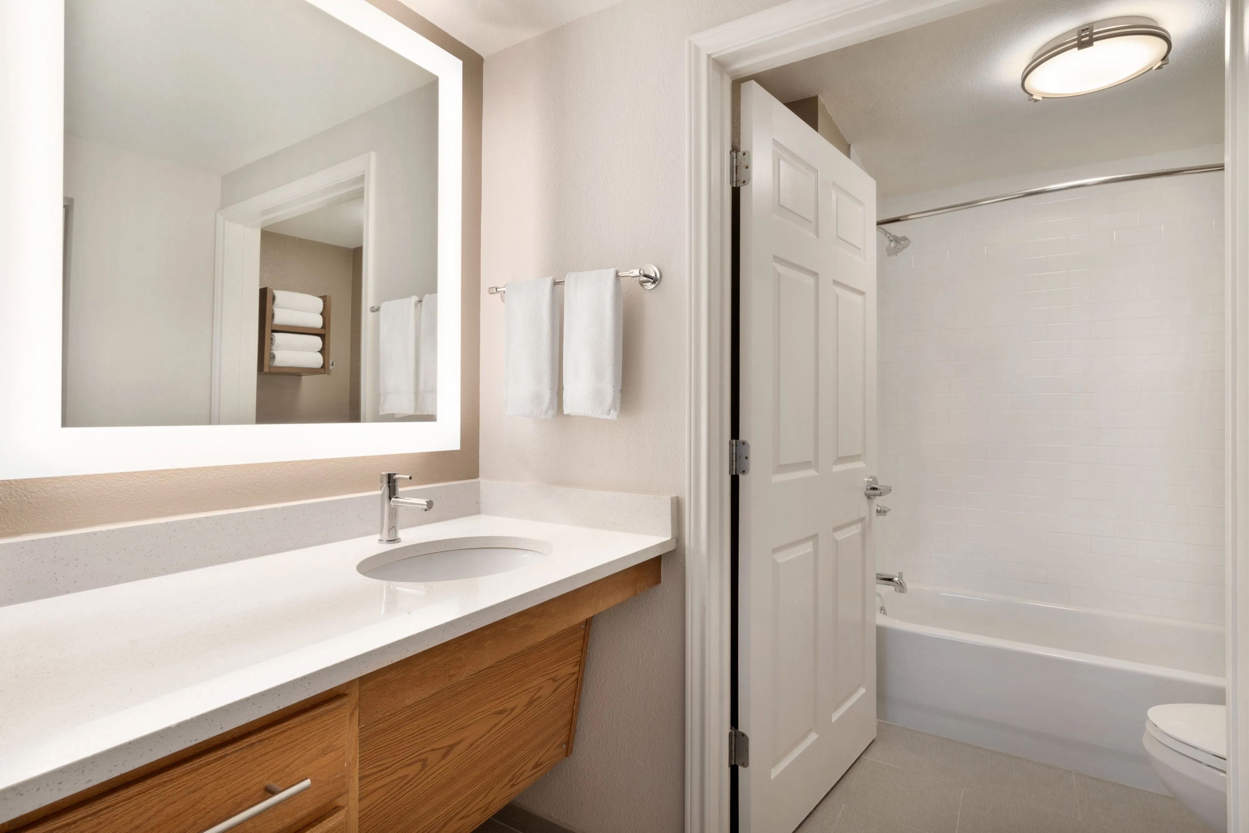 image Bright bathroom featuring a spacious vanity and modern fixtures.