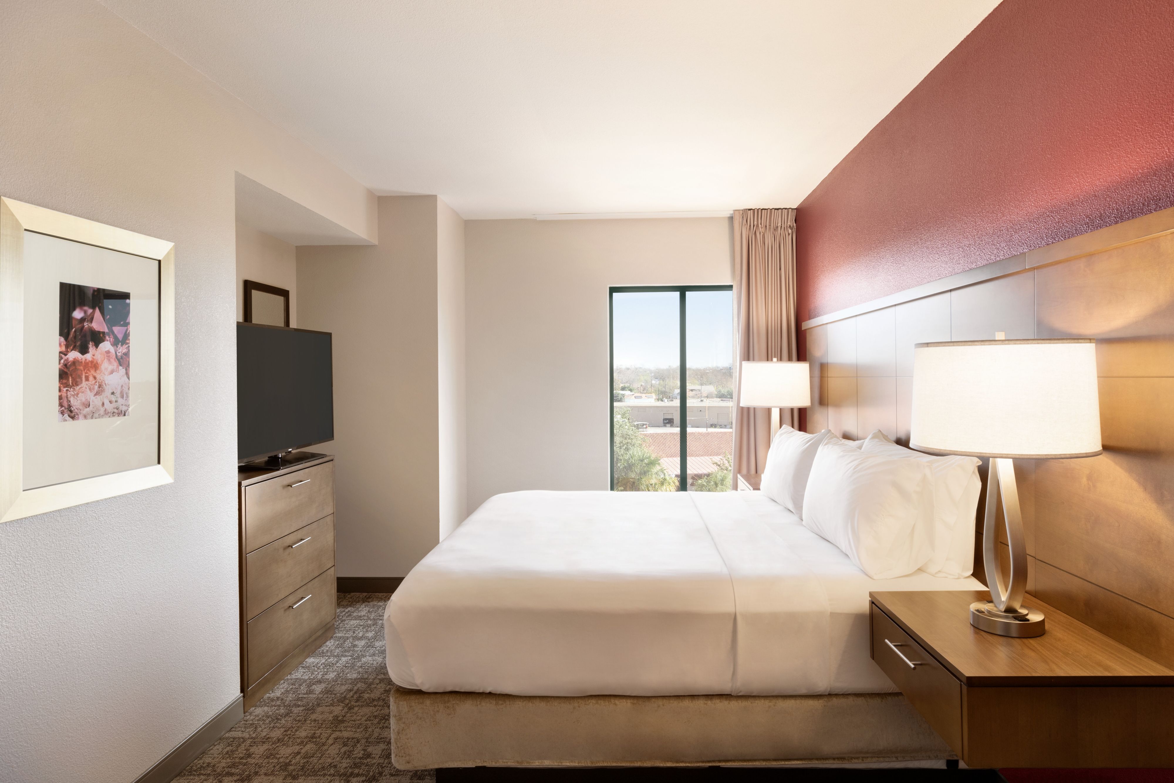 image Plush bedroom with a cozy queen bed and TV.