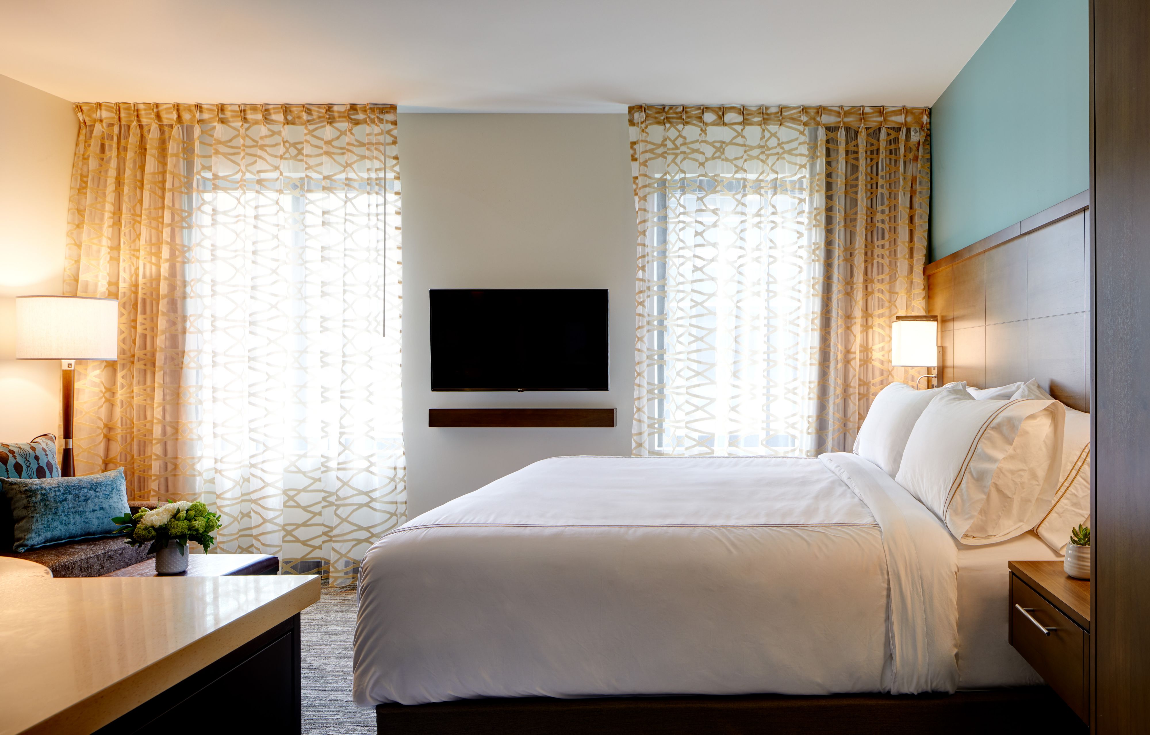 image Bedroom with king bed, TV, and curtains.