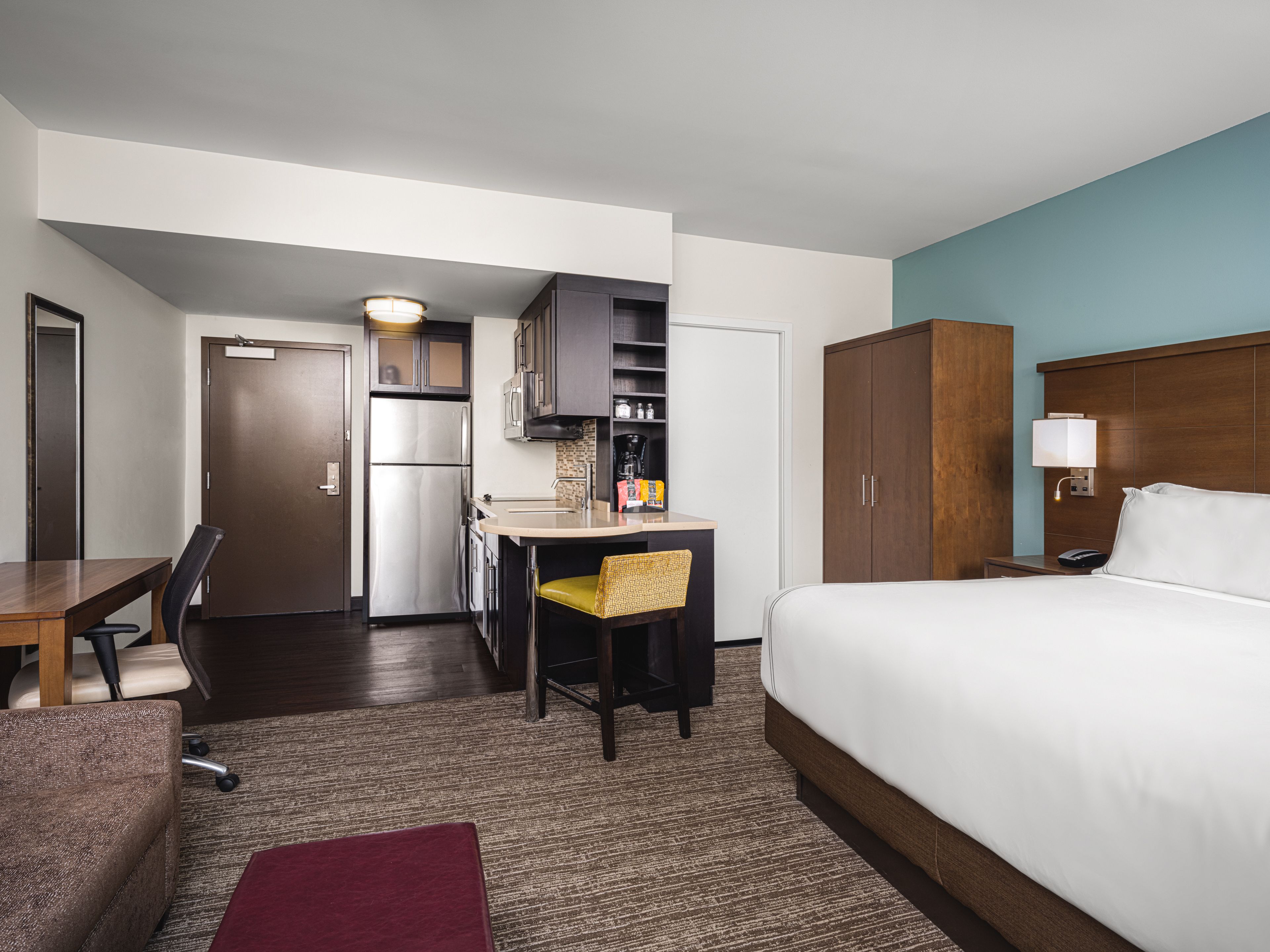 image Studio suite with king bed, kitchen, table, and chair.