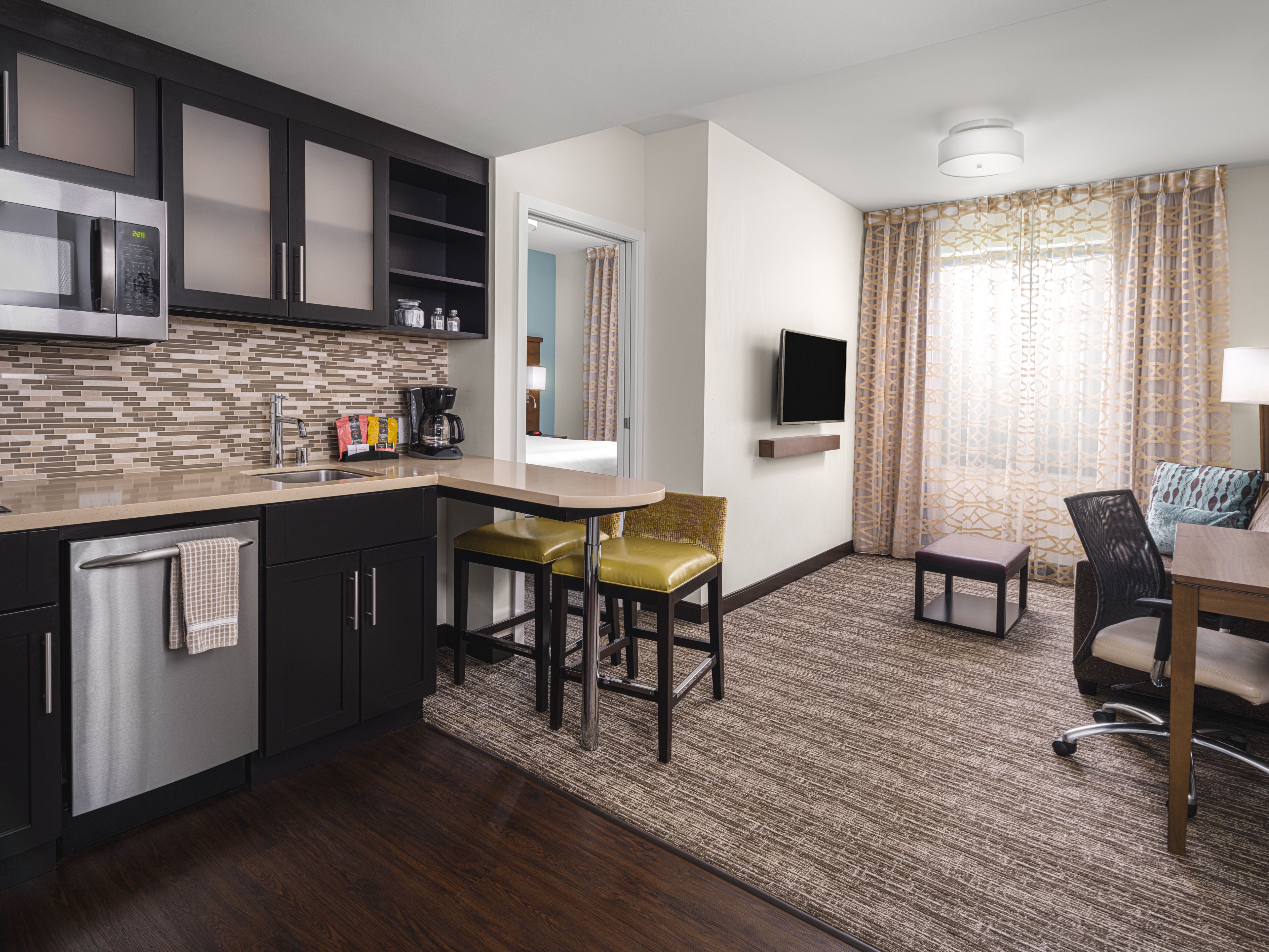 image Open kitchen and living area with dining table and TV.