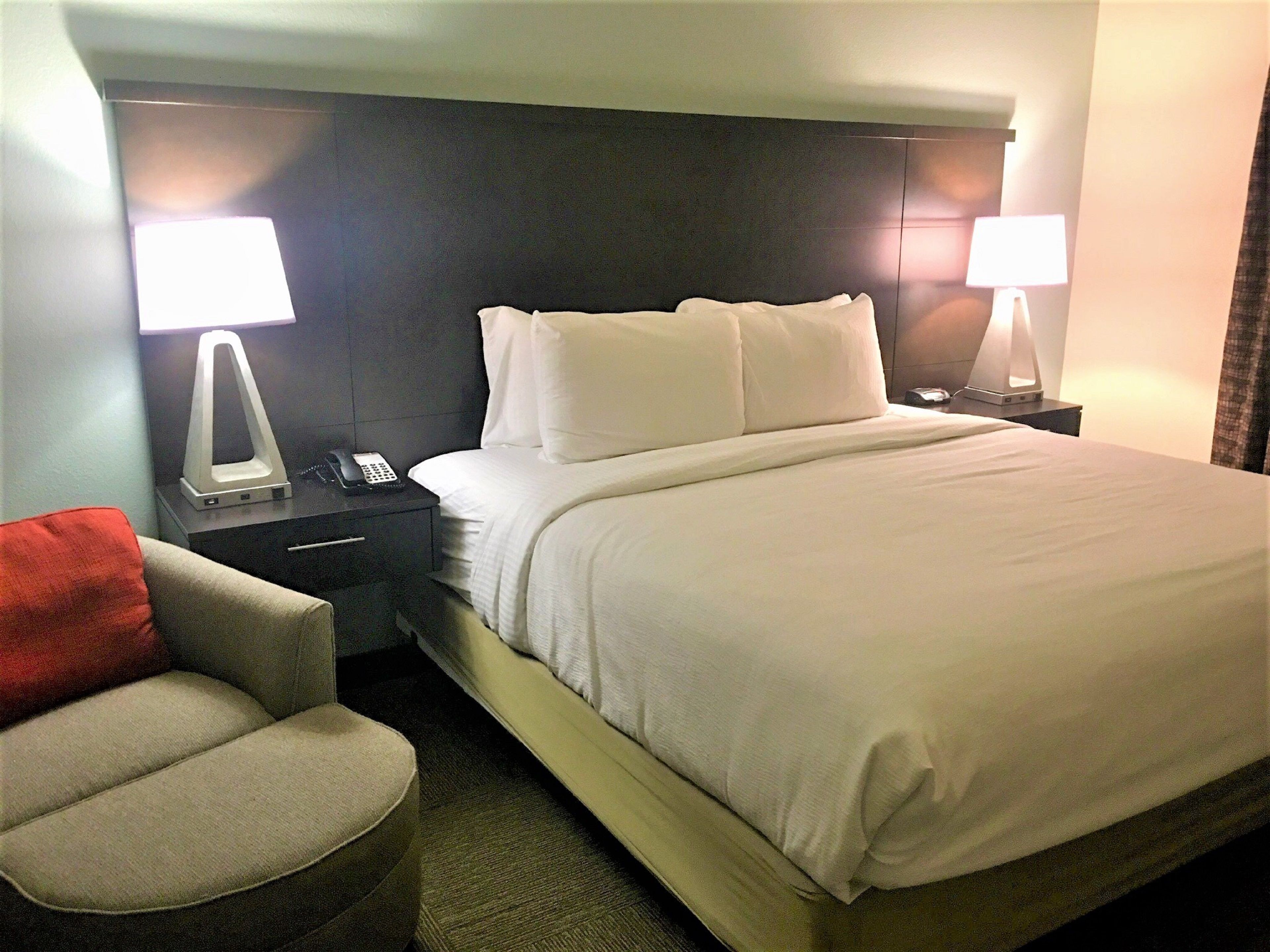 image Enjoy a tranquil night in this inviting bedroom, complete with plush bedding and stylish decor.