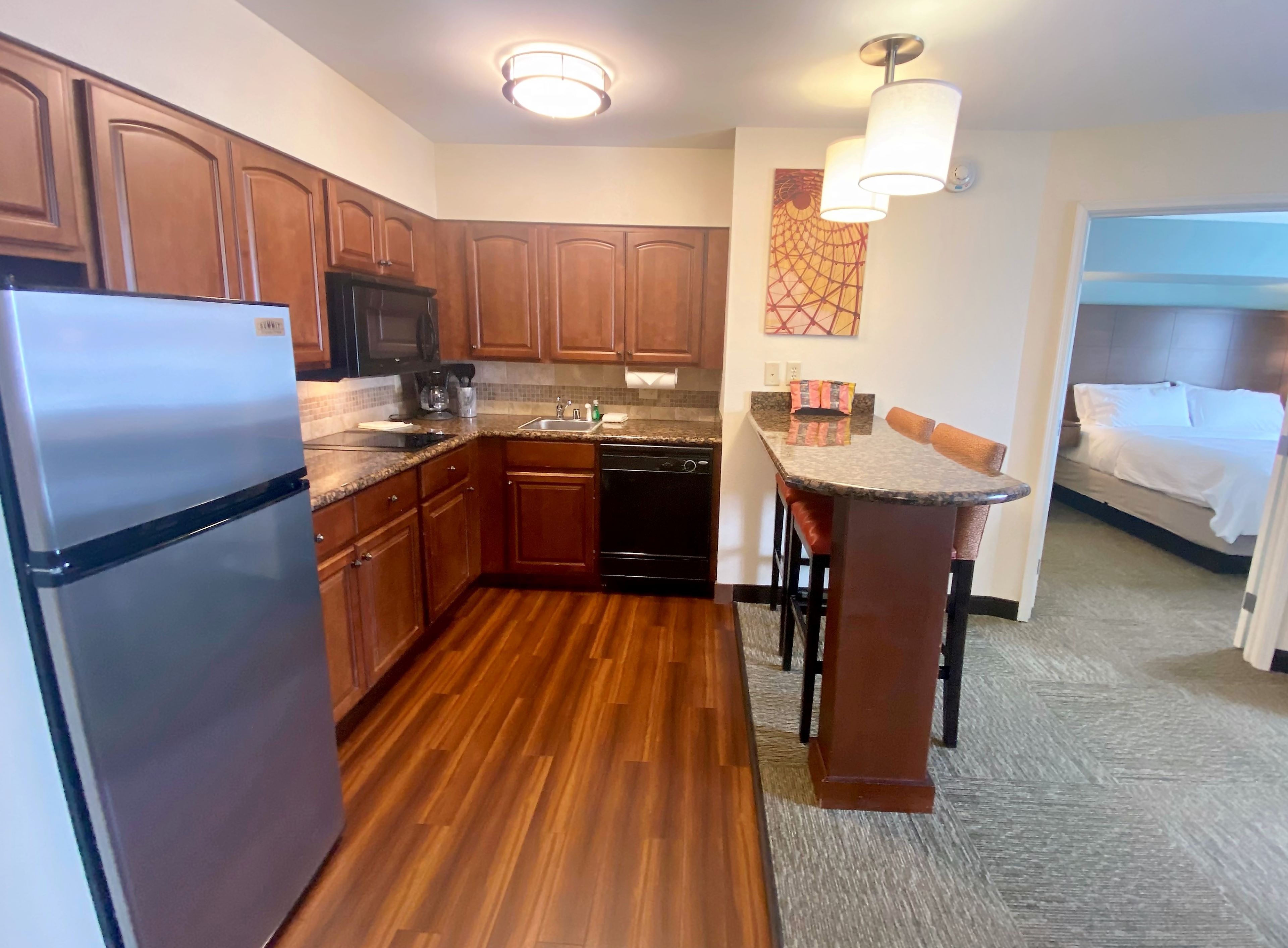 image Create culinary delights in a fully equipped kitchen featuring sleek appliances and a cozy breakfast bar.