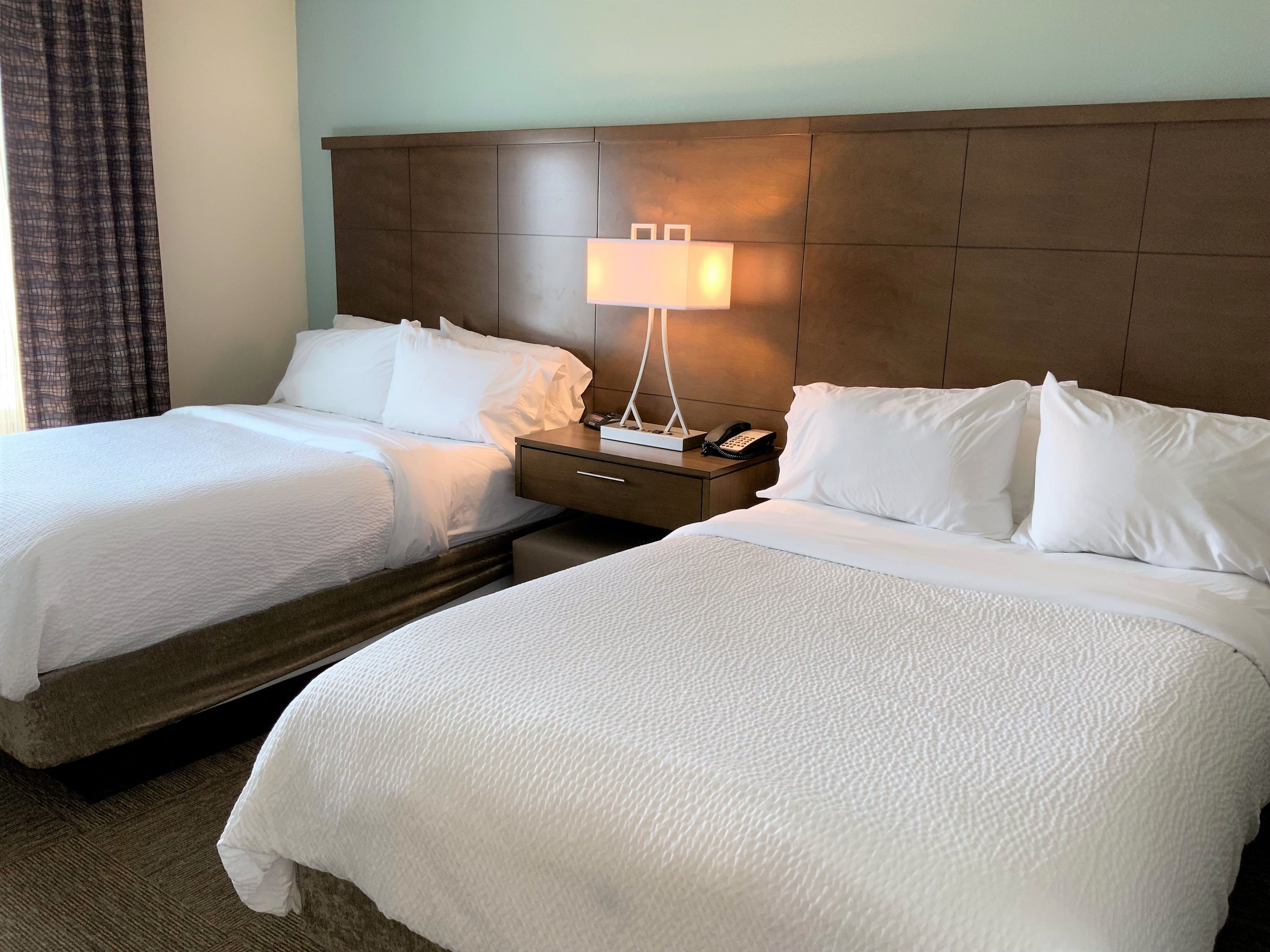 image Relax in a cozy private bedroom featuring two inviting double beds and crisp white linens.