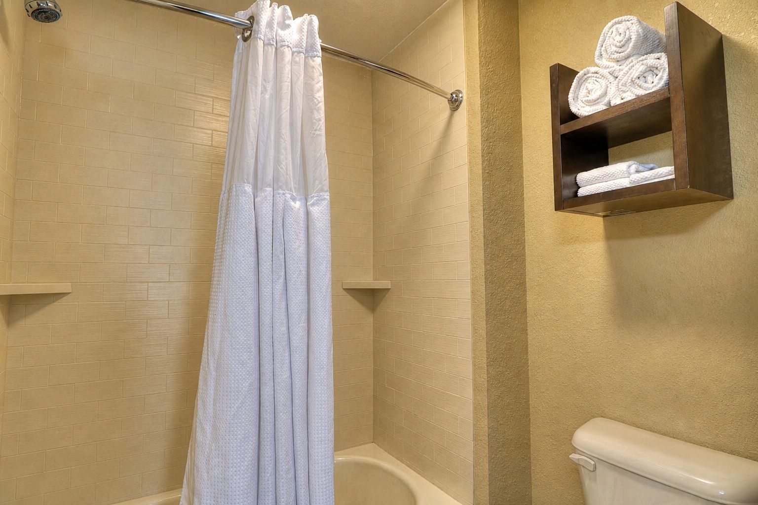 image Clean bathroom with shower and neatly arranged towels.