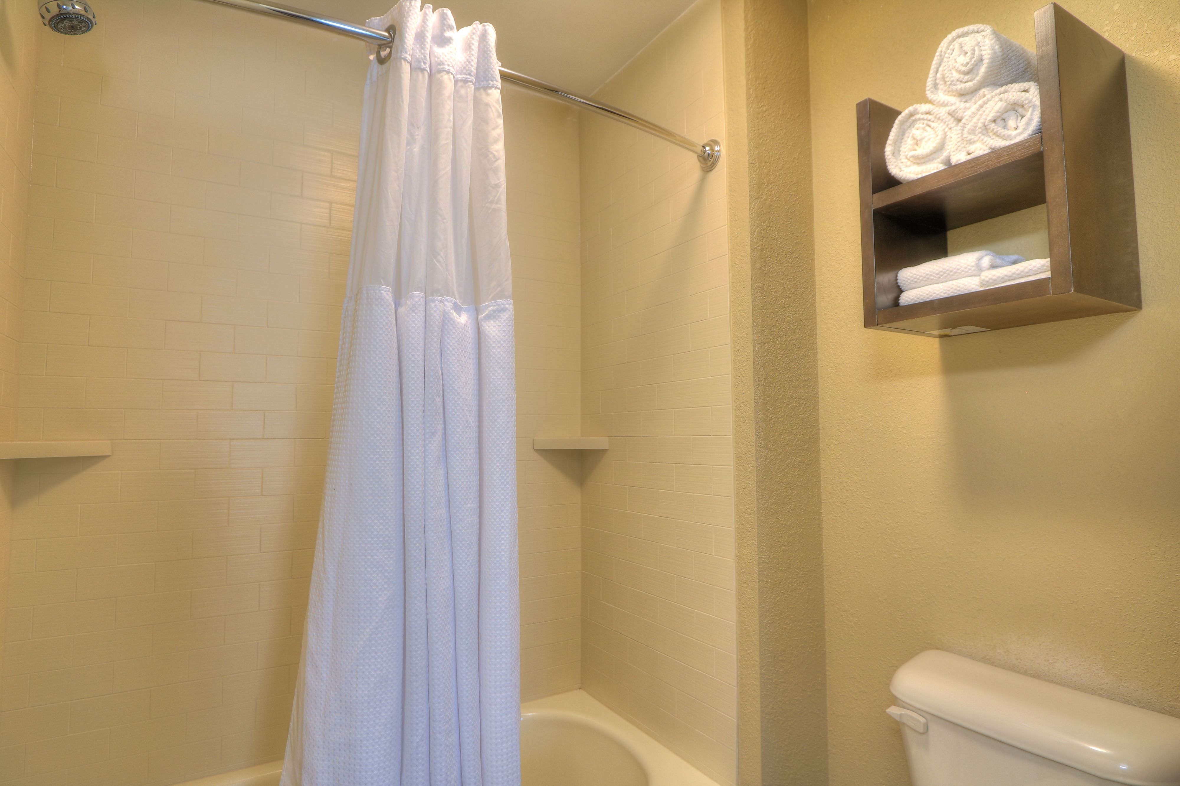 image Clean bathroom with shower and neatly arranged towels.