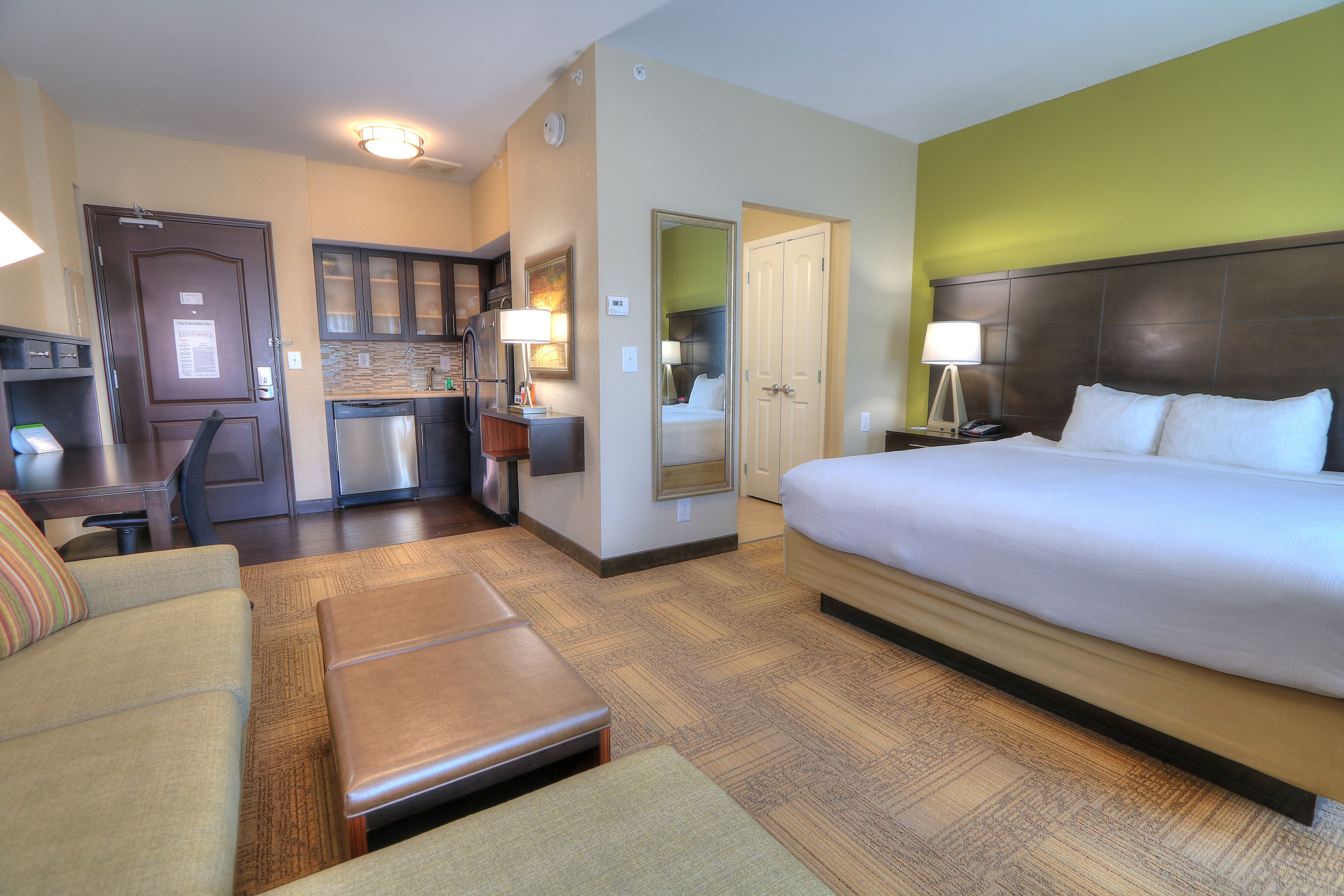 image Cozy king studio suite with comfortable bed and kitchen.