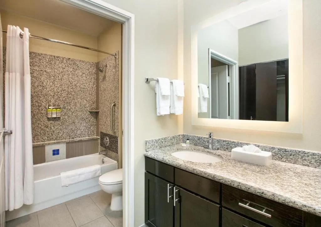 image Accessible bathroom with a tub, grab bars, and vanity