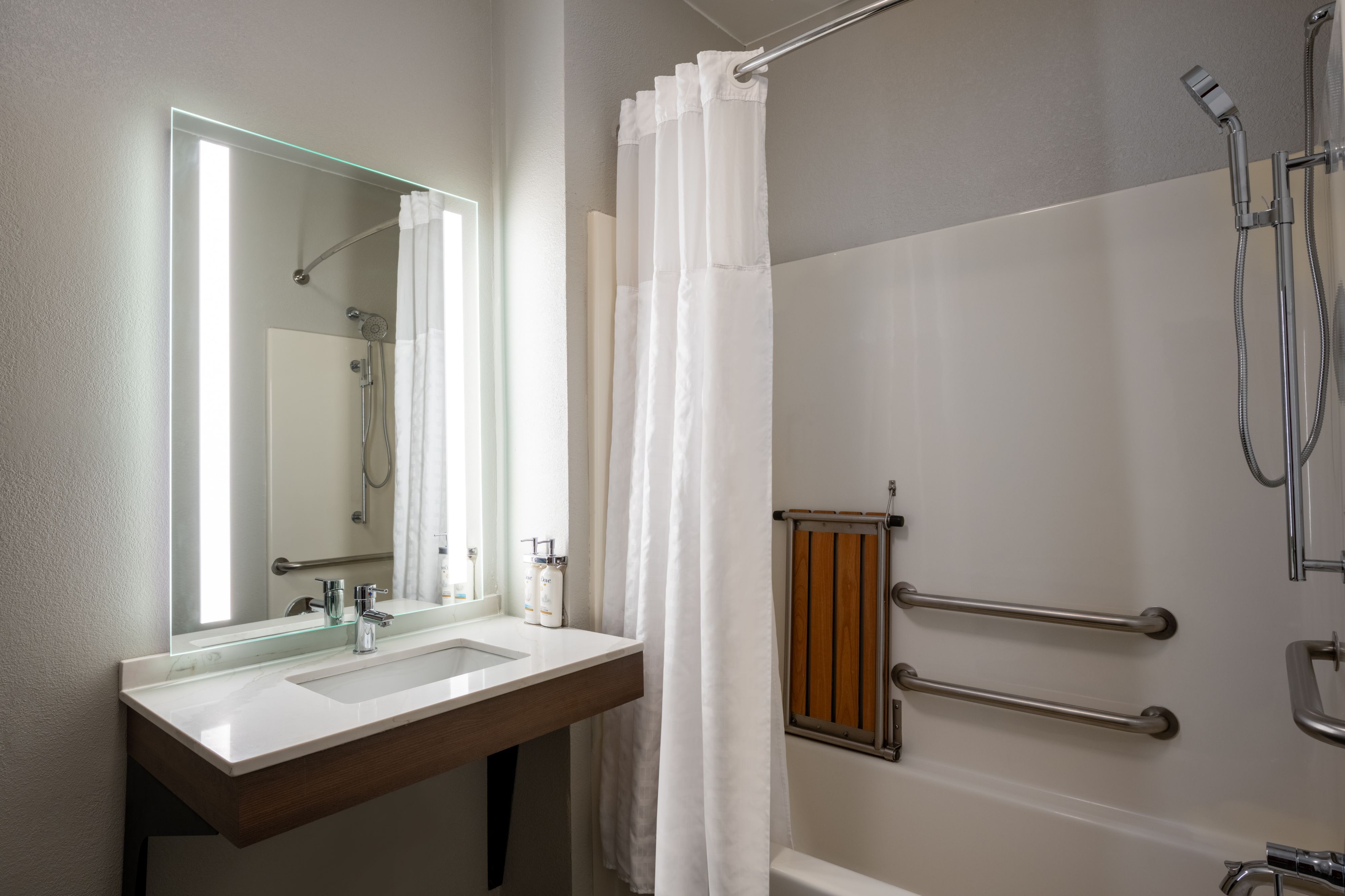 image Bathroom with walk-in shower, sink, and vanity mirror.