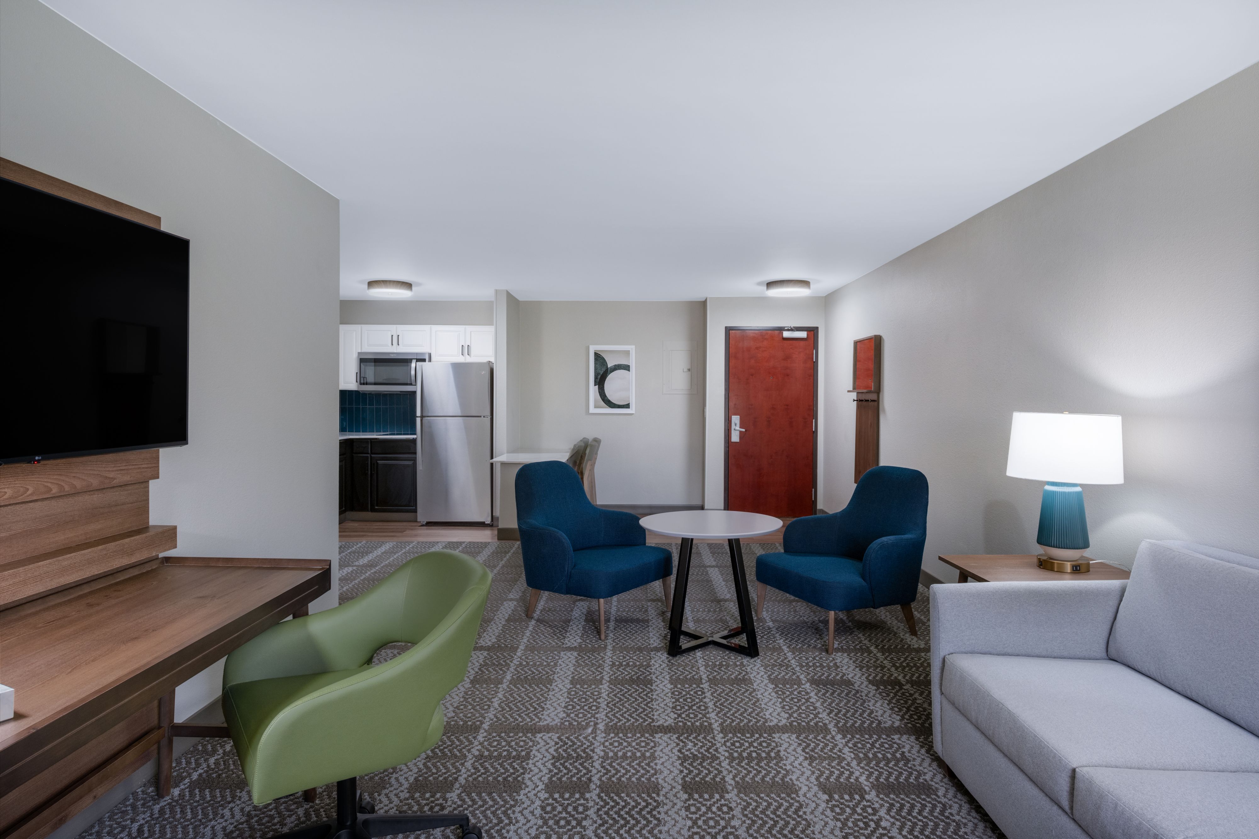 image Living area with sofa, kitchenette, TV, and dining table.