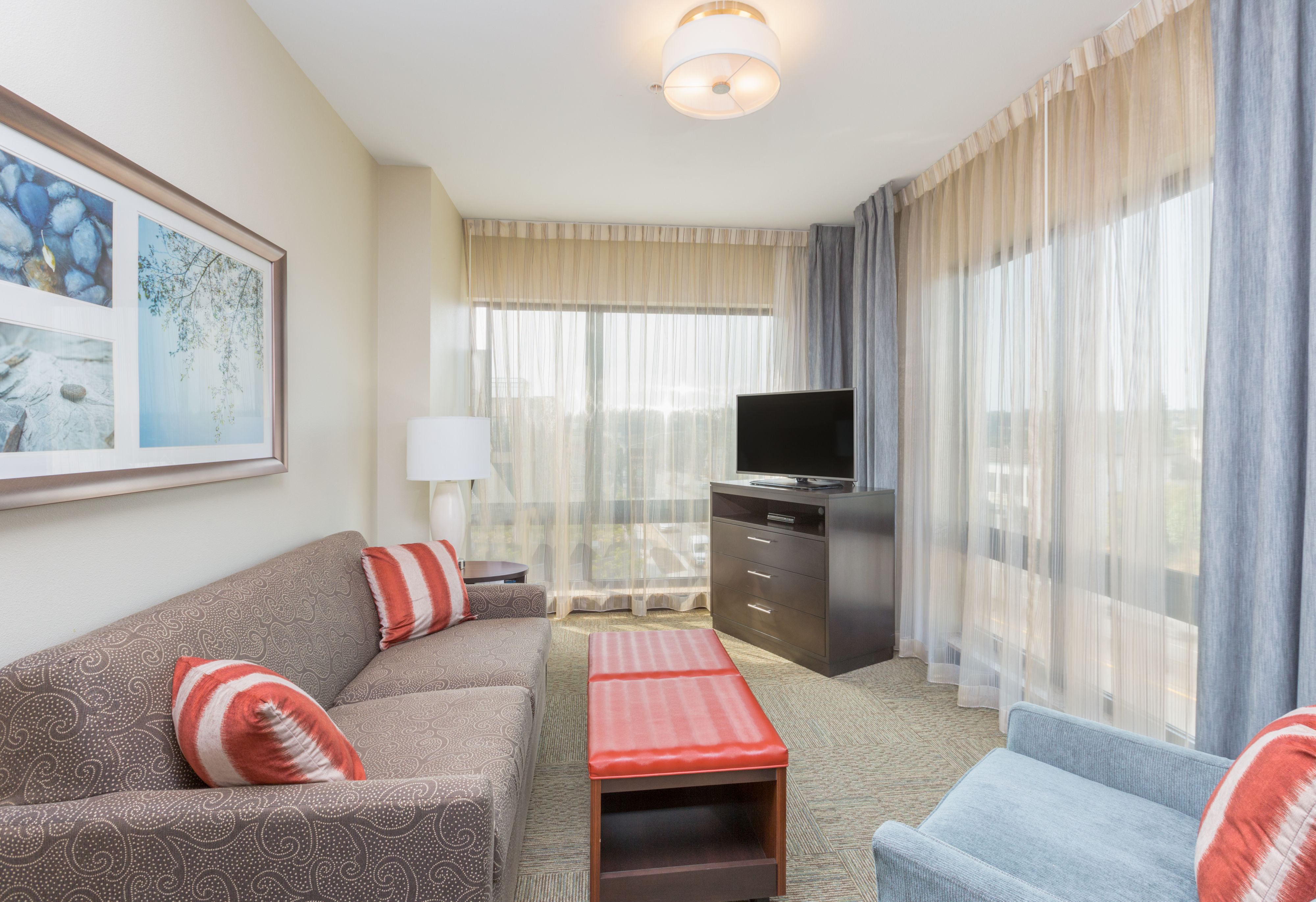 image Cozy living area with plush seating, a flat-screen TV, and natural light.