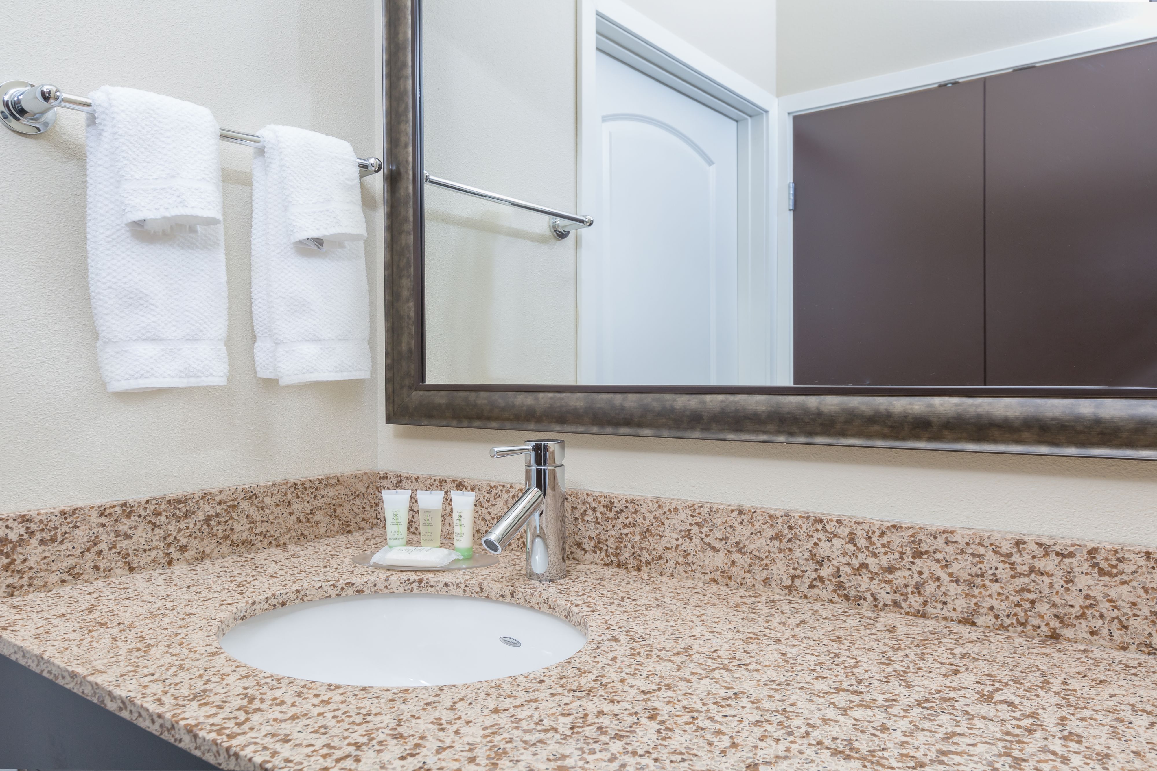 image Stylish bathroom featuring a sleek countertop, modern faucet, and fresh towels.