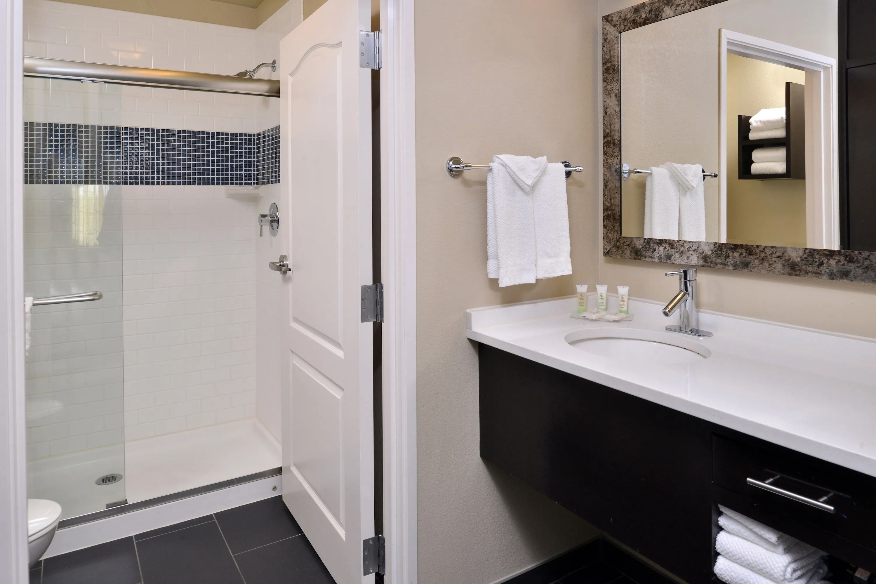 image Bathroom with walk-in shower, vanity sink, mirror, and towels.