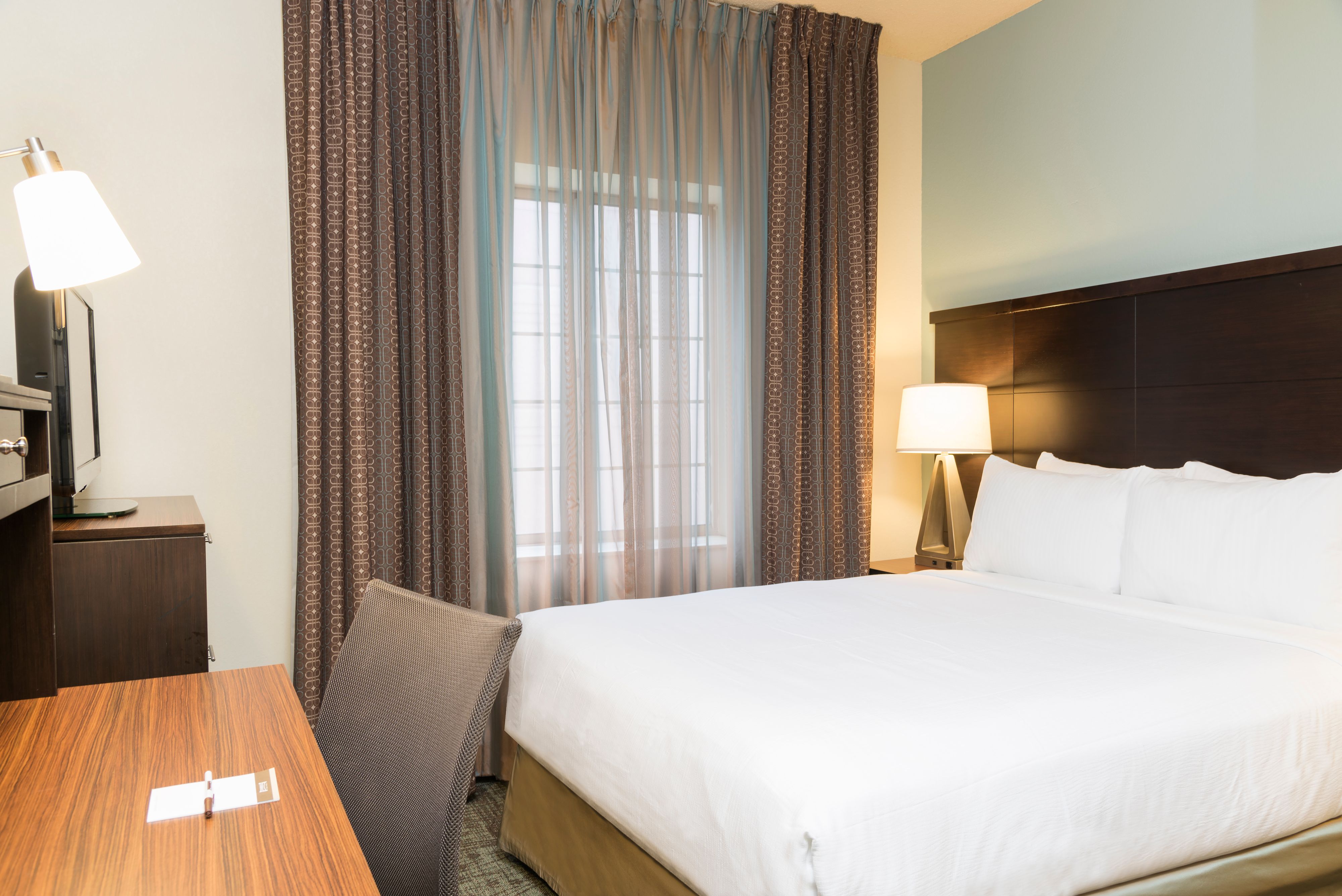 image Inviting room with a queen bed and a flat-screen TV.