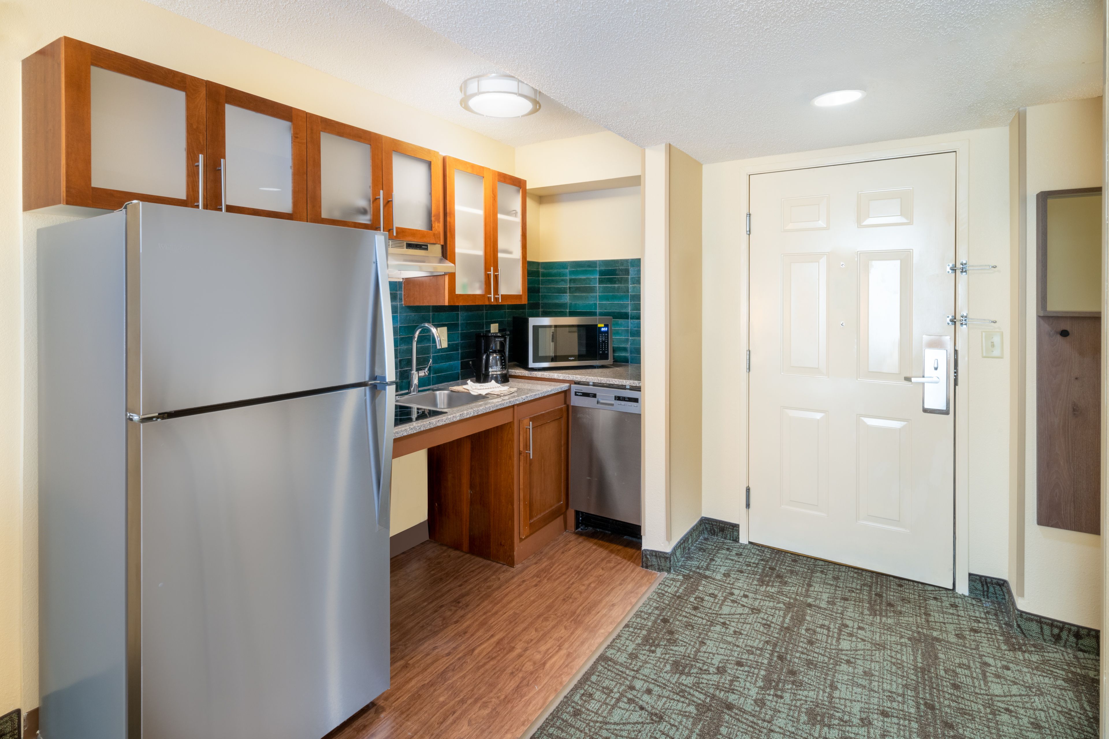 image Modern kitchen with stainless steel appliances and vibrant backsplash.