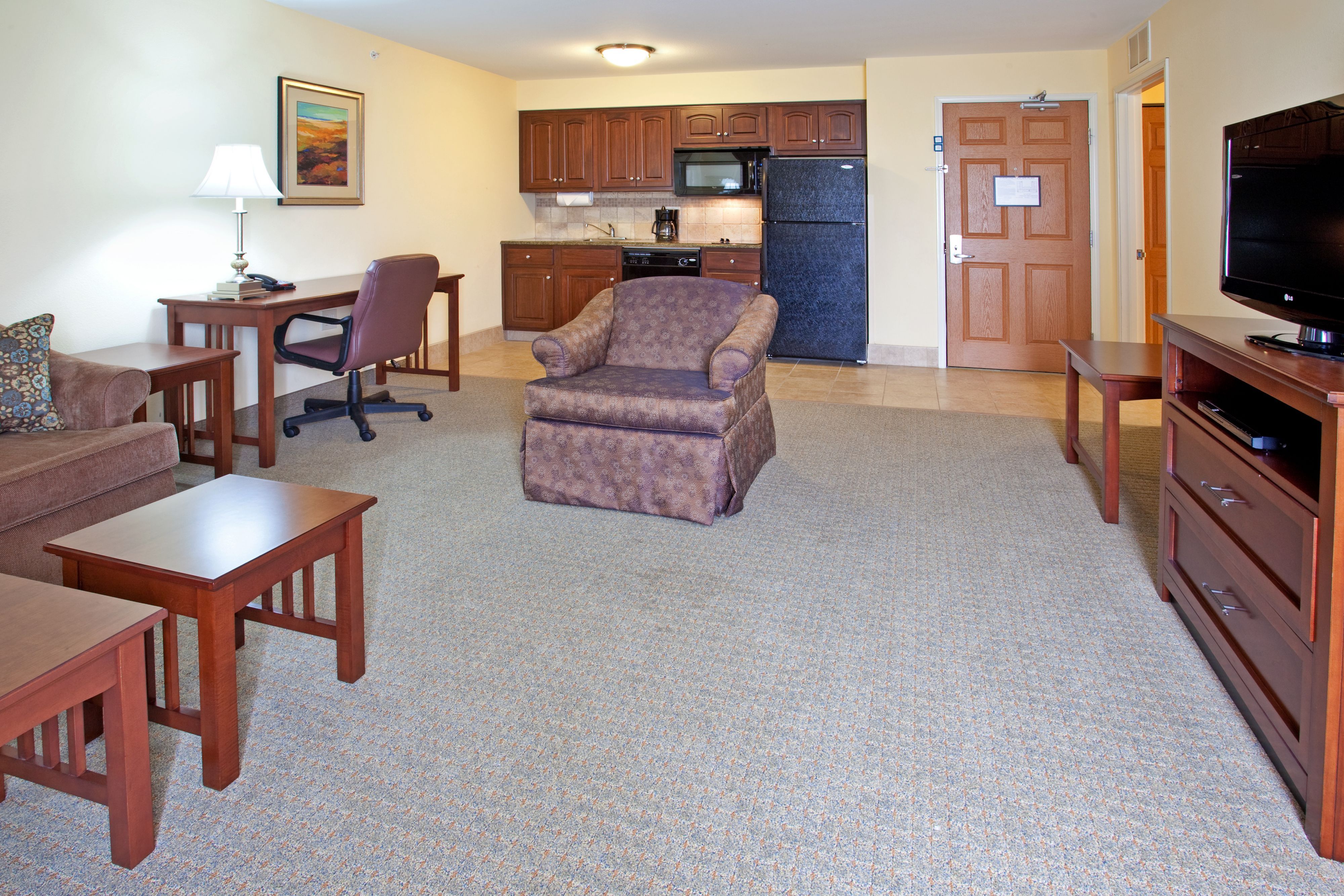 image Cozy living area with comfortable seating, desk, and full kitchen.