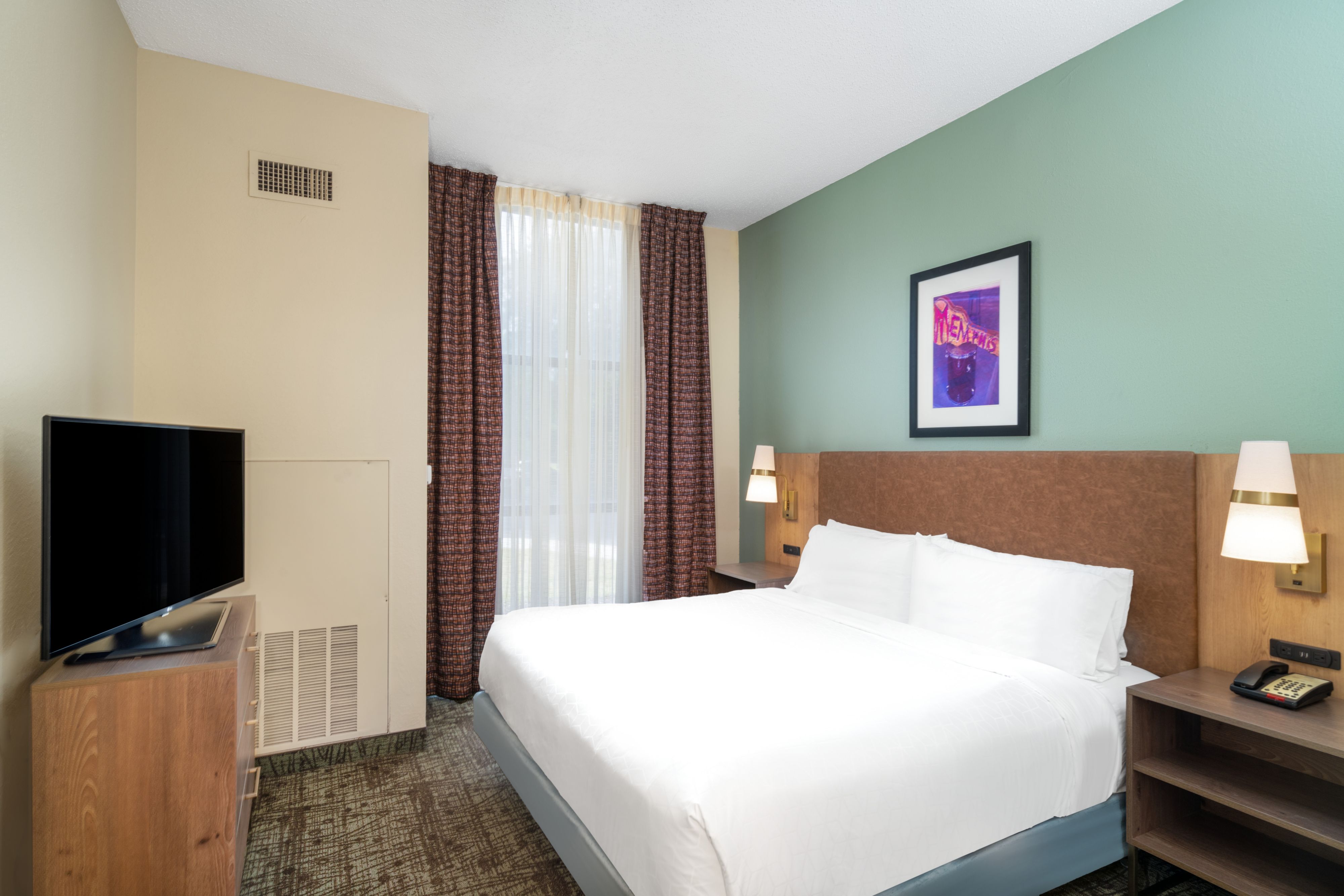 image Comfortable king bedroom with large bed and natural light.