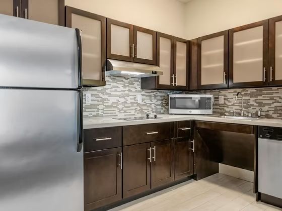 image Kitchen with stainless steel appliances, dark cabinetry, tile backsplash, and dishwasher