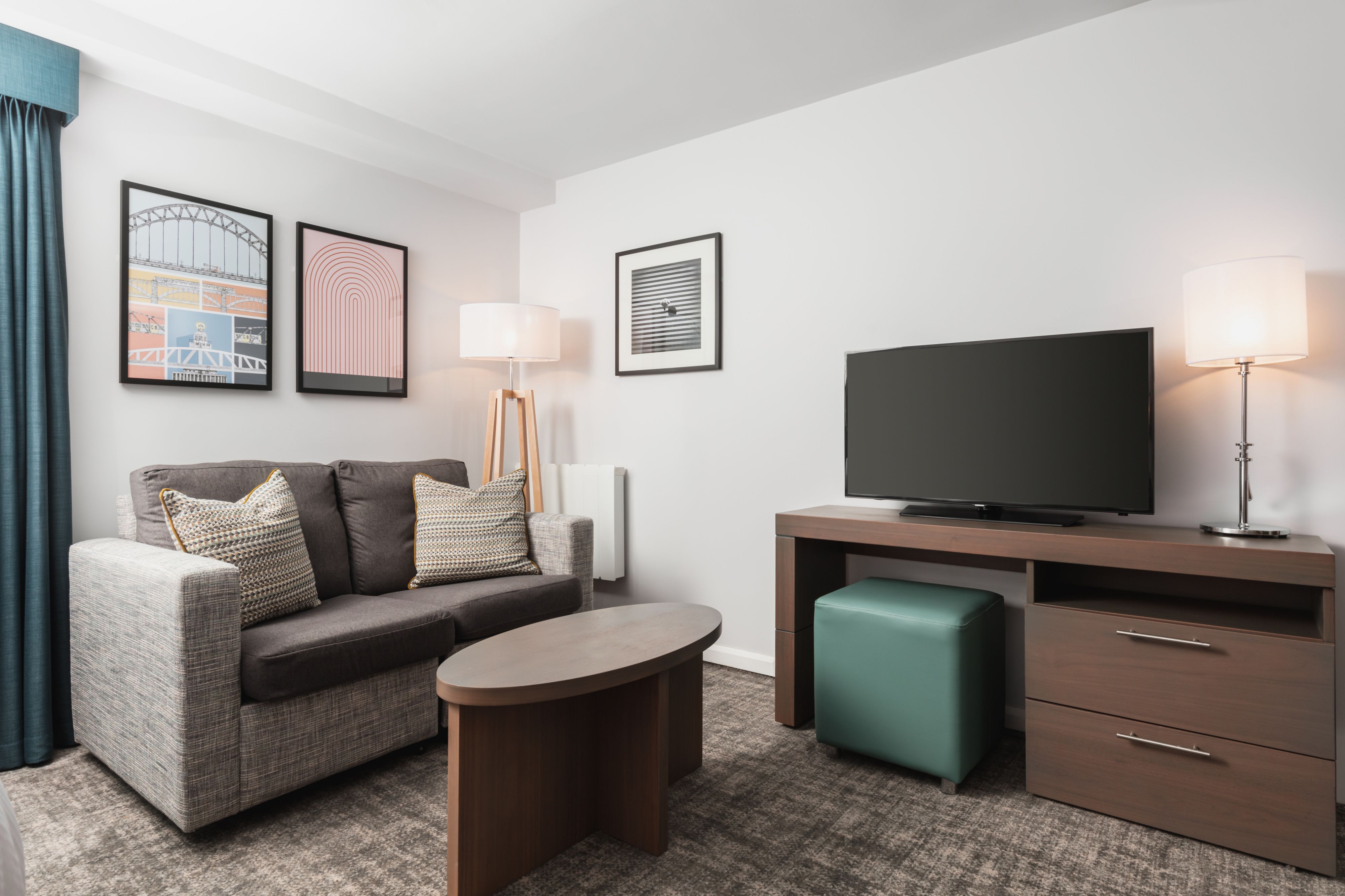 image Living area with sofa, coffee table, and flat-screen TV.