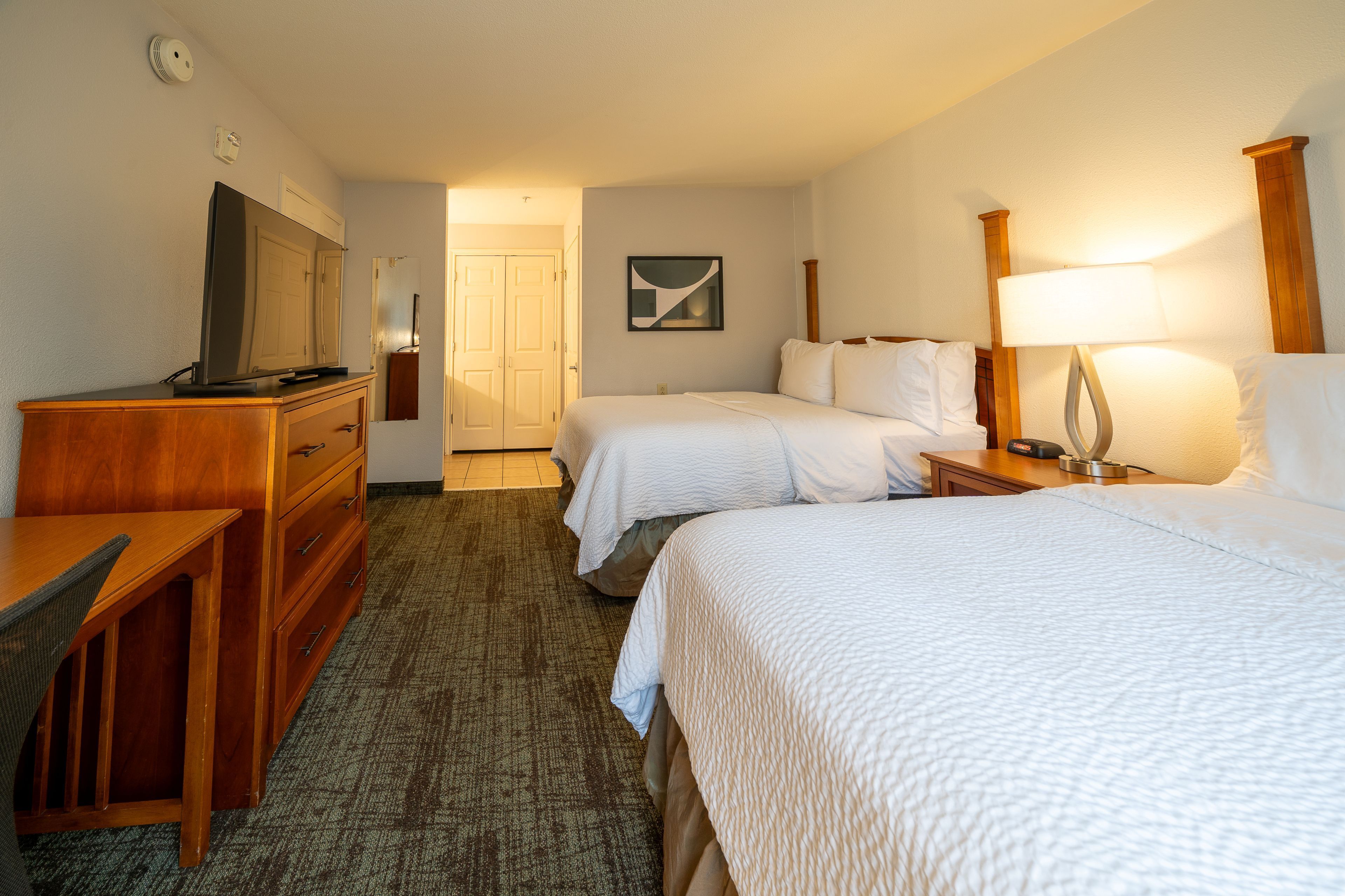 image Bedroom with two double beds, TV, and dresser.