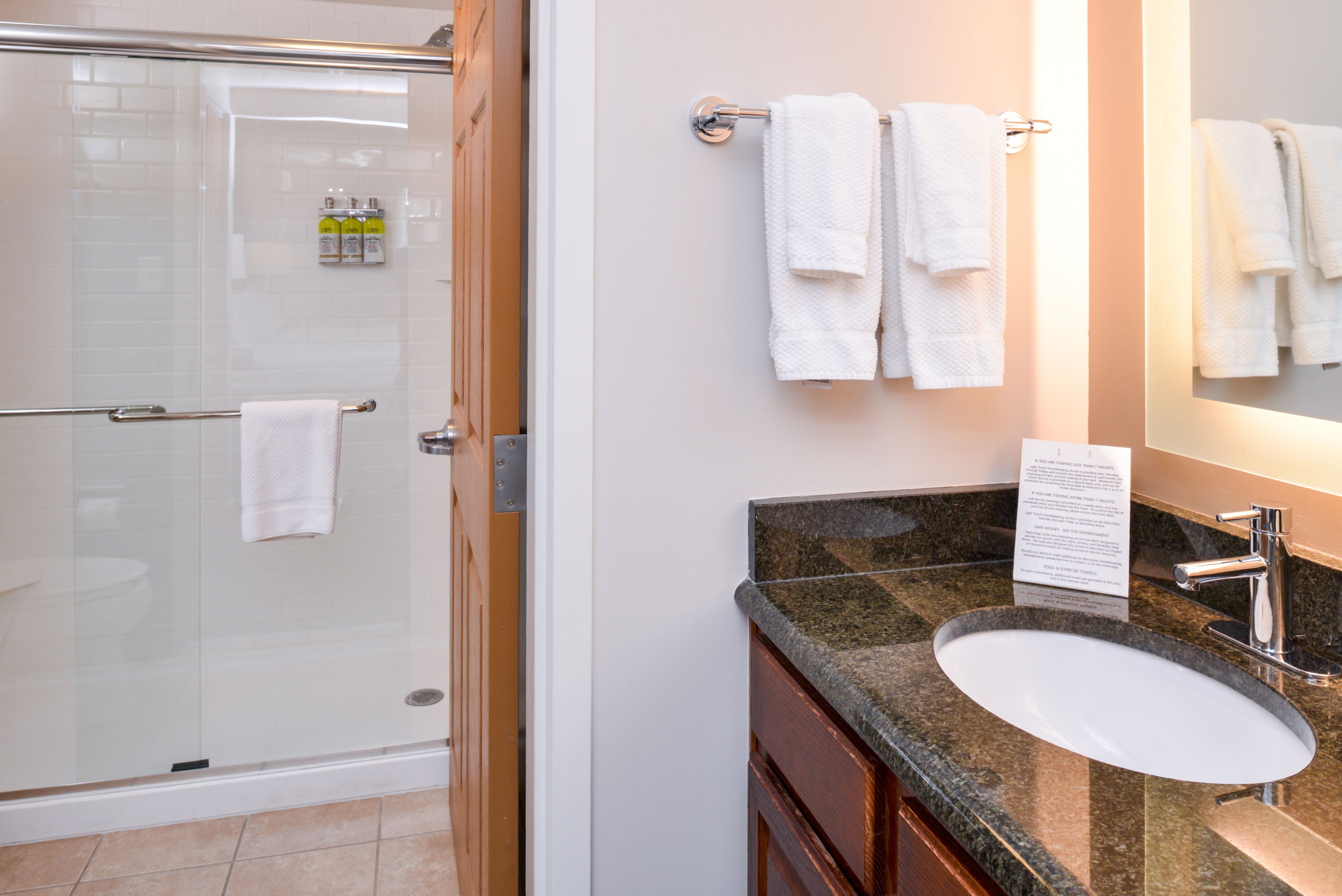 image Elegant bathroom with granite countertop and glass shower.