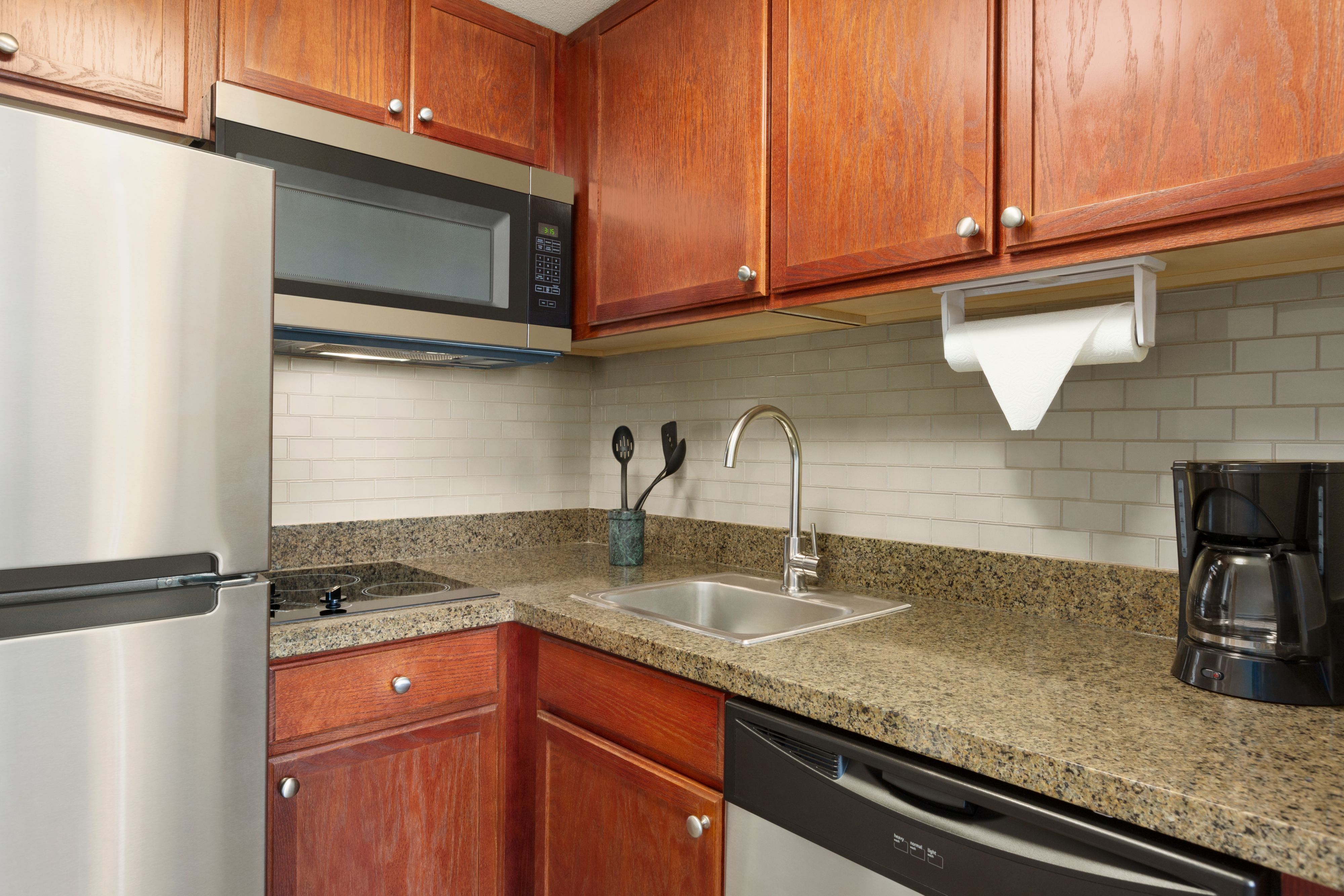 image Fully equipped in-suite kitchen with stove, microwave, and refrigerator.