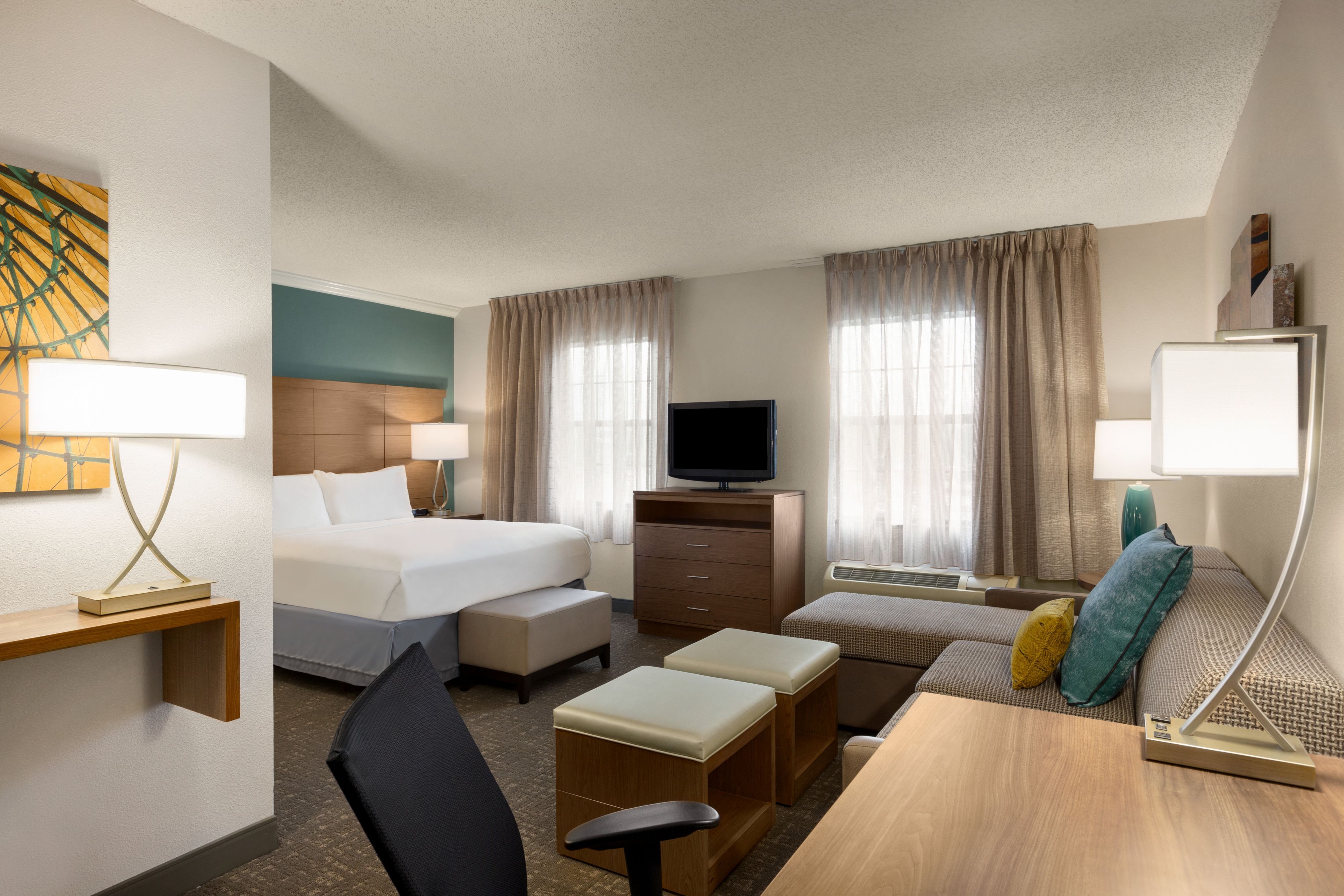 image Comfortable bedroom with plush bedding and dedicated work desk.
