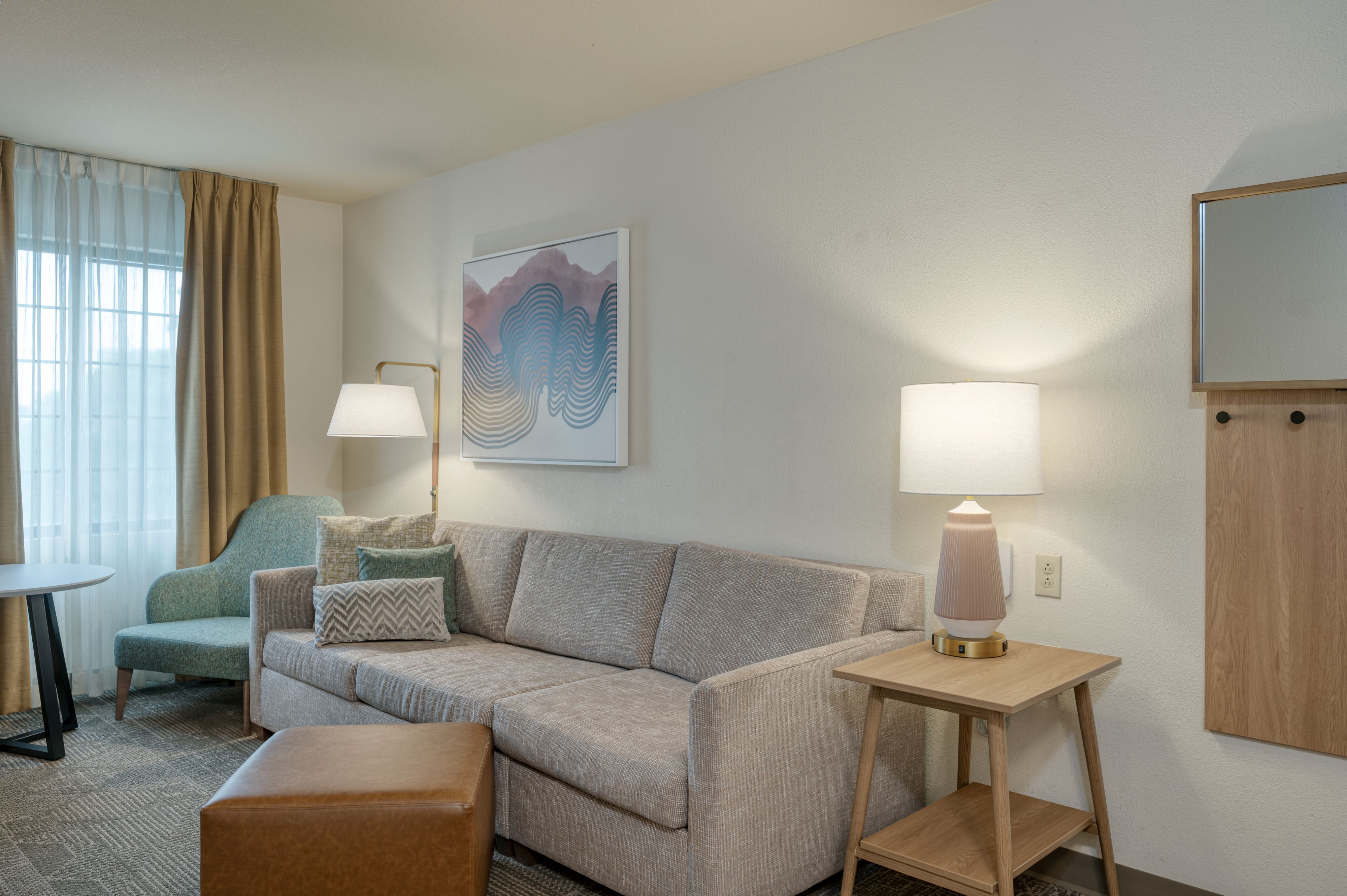 image Living area with sofa, accent chair, and large window.