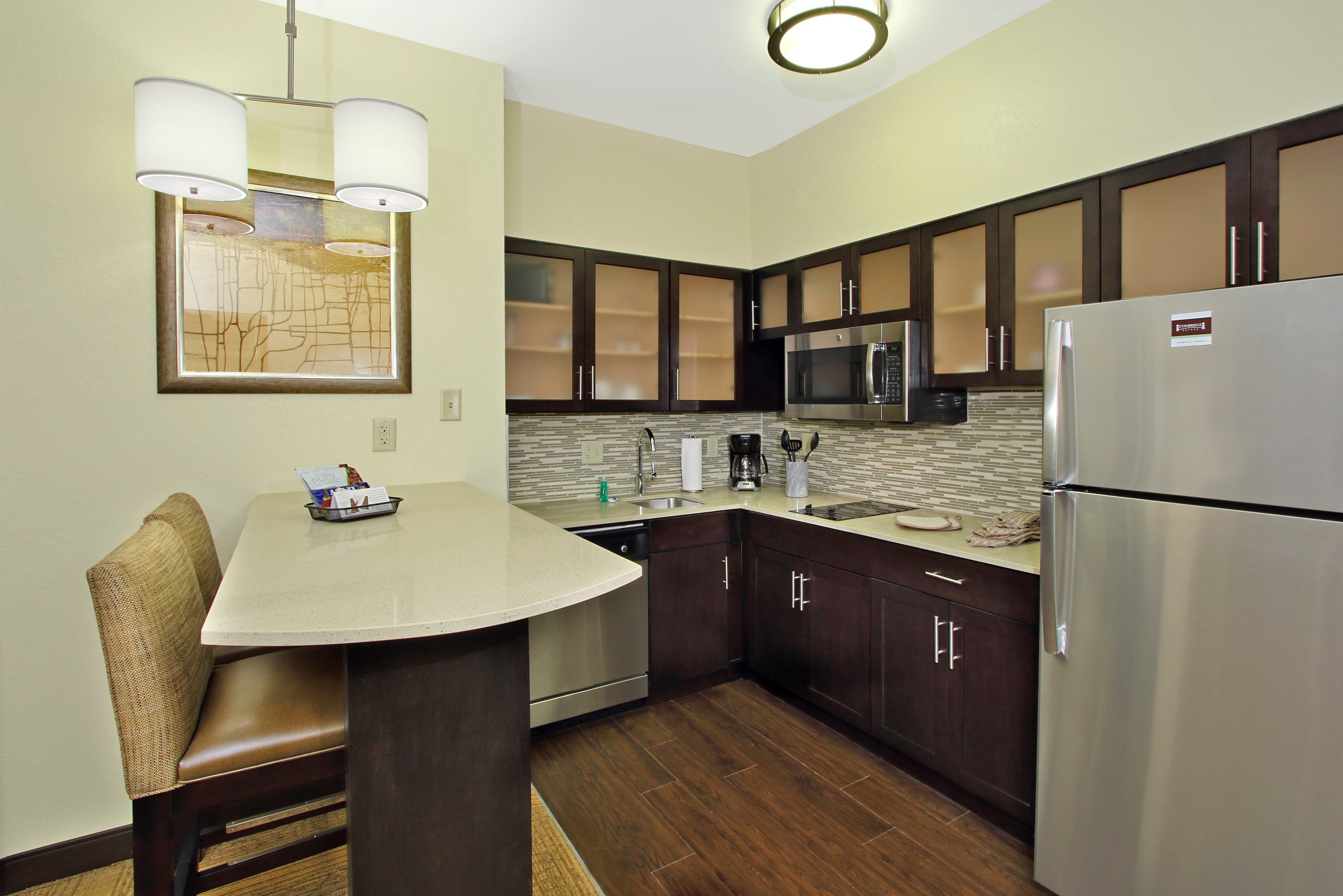 image Kitchen with stainless steel appliances, dark cabinetry, and breakfast bar seating.