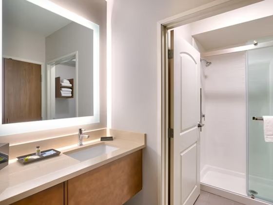 image Bathroom with glass-enclosed shower, vanity, and towel storage.