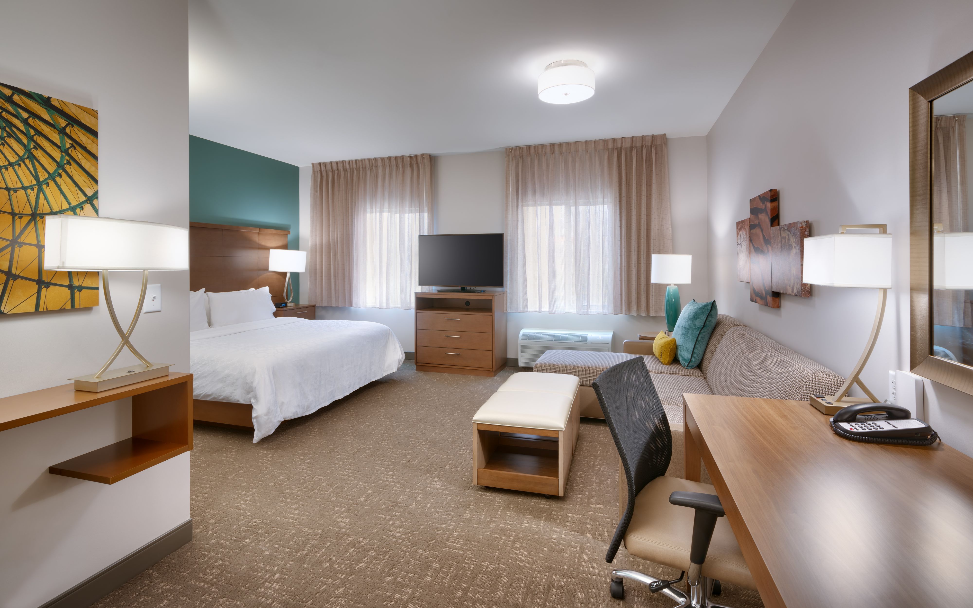 image Studio room with queen bed, sofa bed, desk, and flat-screen TV.