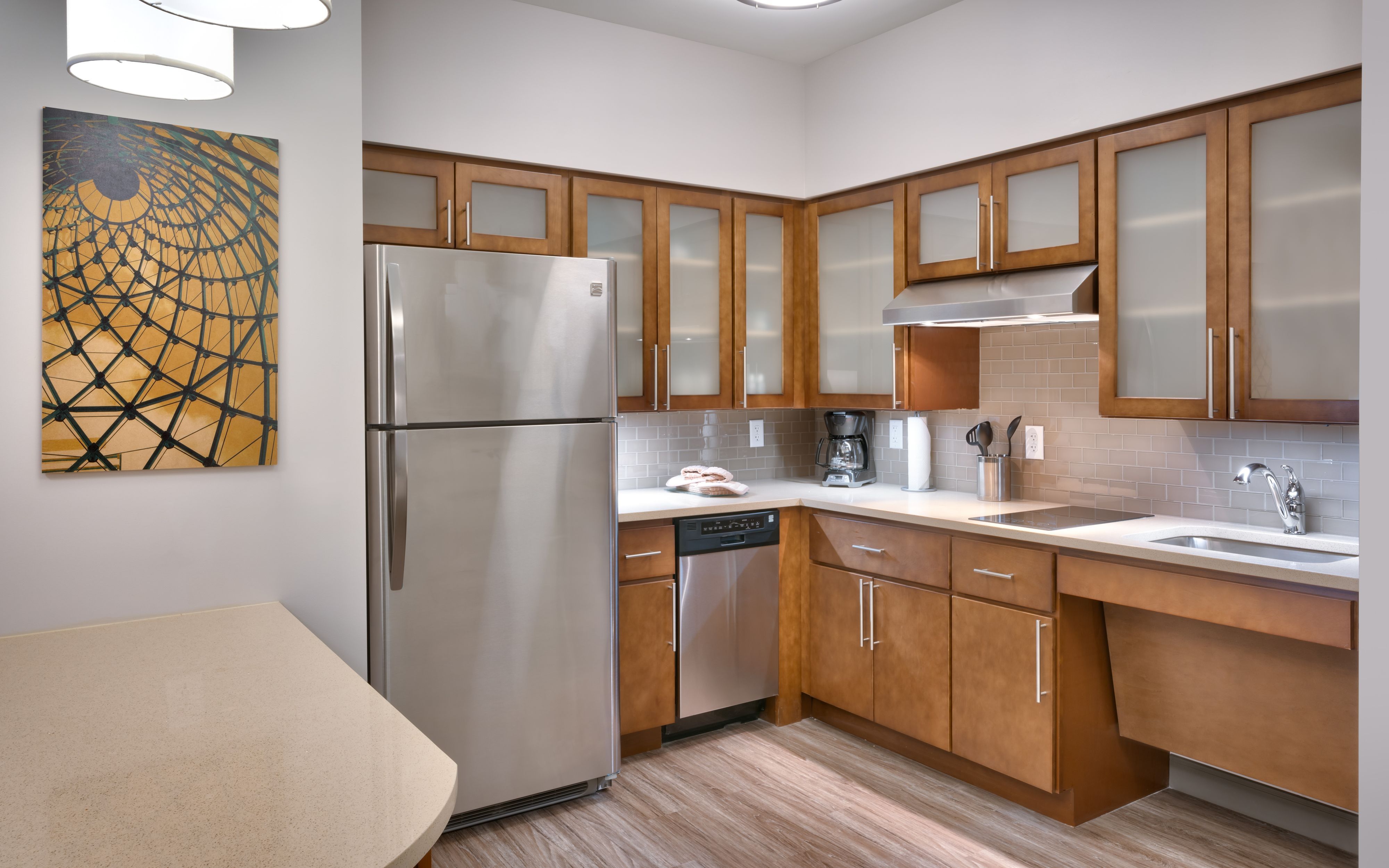 image Modern kitchen with stainless steel appliances and wooden cabinets.